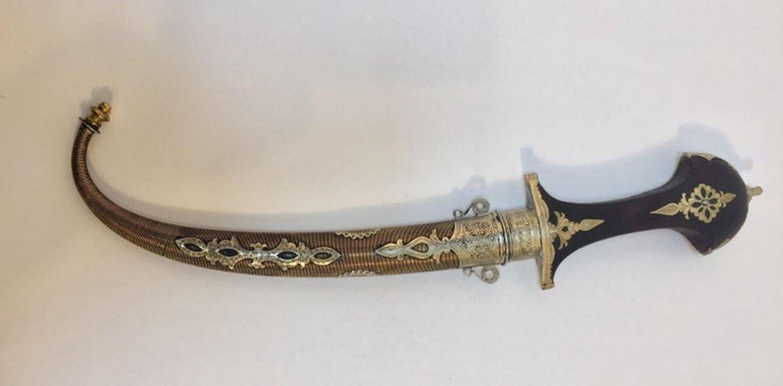 Daga de colección Khoumya tribal marroquí, vintage de los años 50.
Hecho a mano por artesanos en Marruecos, artesanía de calidad muy fina con empuñadura de madera grabada con plata marroquí y cincelada en follaje morisco en forma de volutas.
Puñal