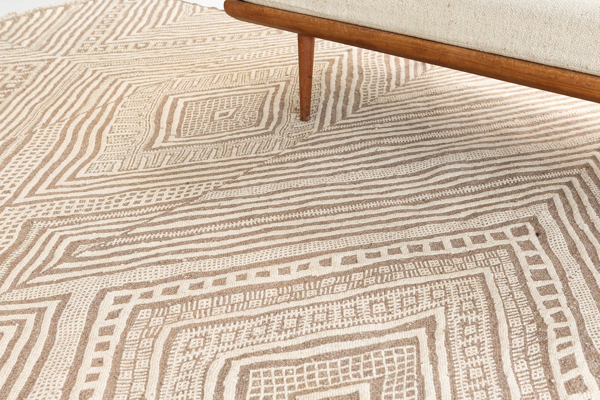 Featuring a charming illusion effect, this Moroccan Kilim rug adds texture and subtle graphic appeal forming a warm, relaxed space. The abrashed field is covered in an all-over diamond effect reminiscent of a kaleidoscope across the tantalizing and
