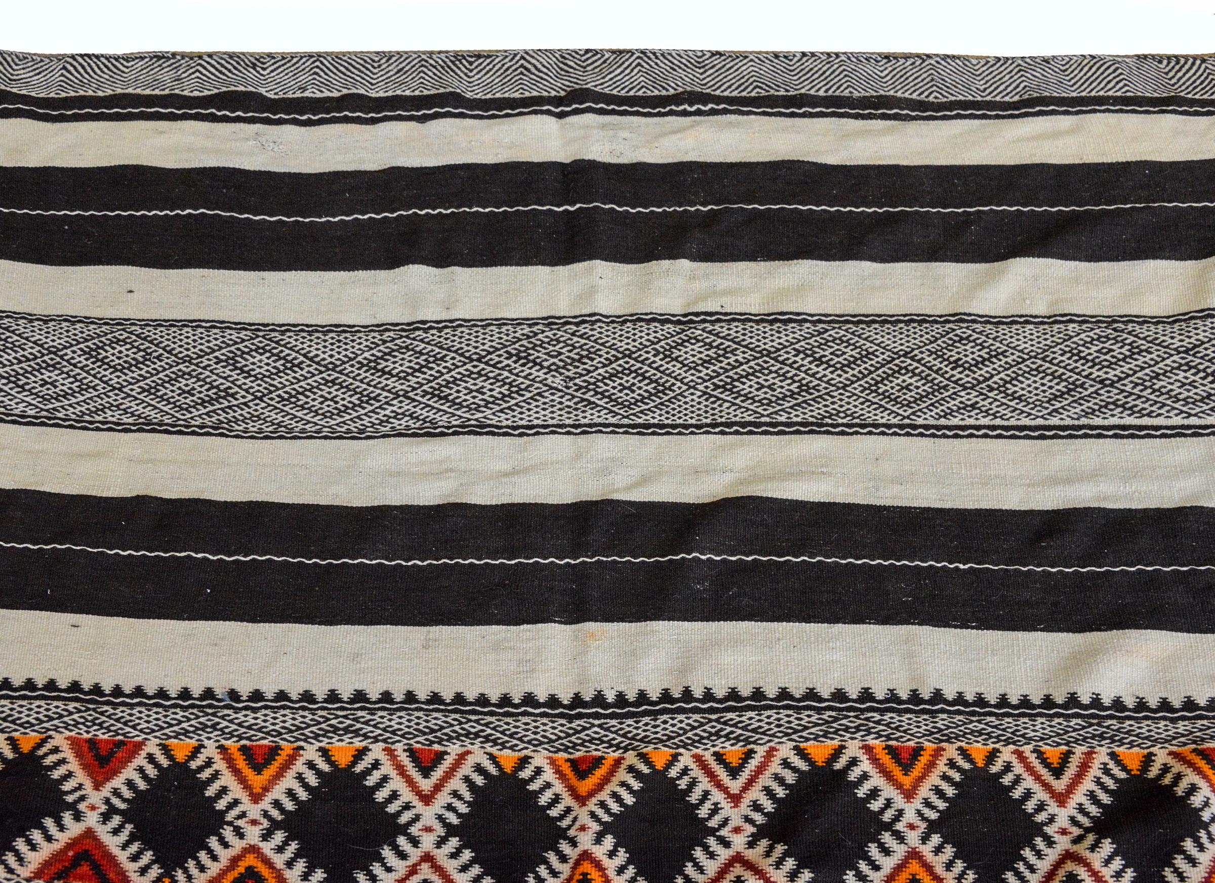 Un magnifique kilim marocain du milieu du 20e siècle avec des rayures multicolores alternées, toutes tissées avec des motifs géométriques.