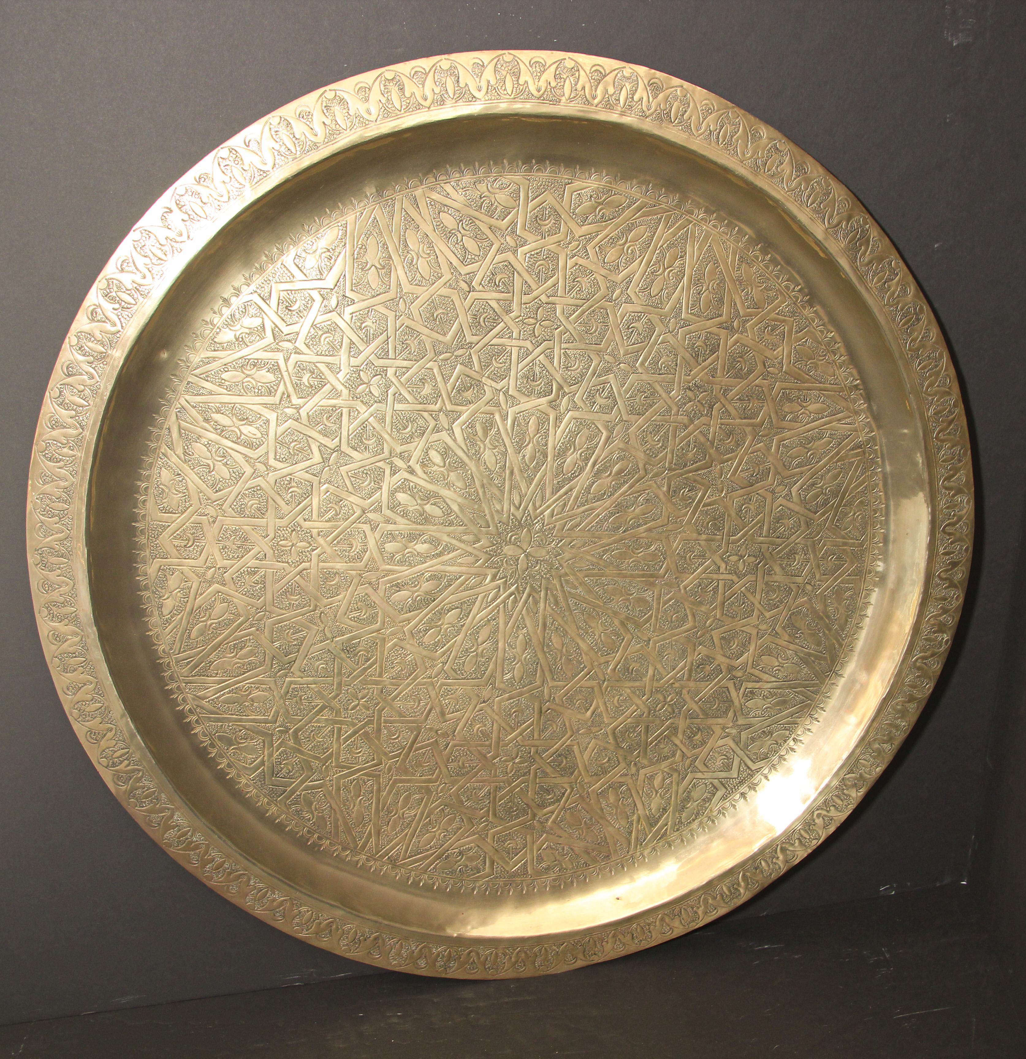 Moroccan large metal polished brass tray platter.
Polished decorative metal brass tray with very fine intricate designs.
Finley hand-hammered and chiseled in floral and geometrical Moorish designs with a star in the middle.
Heavy brass metal