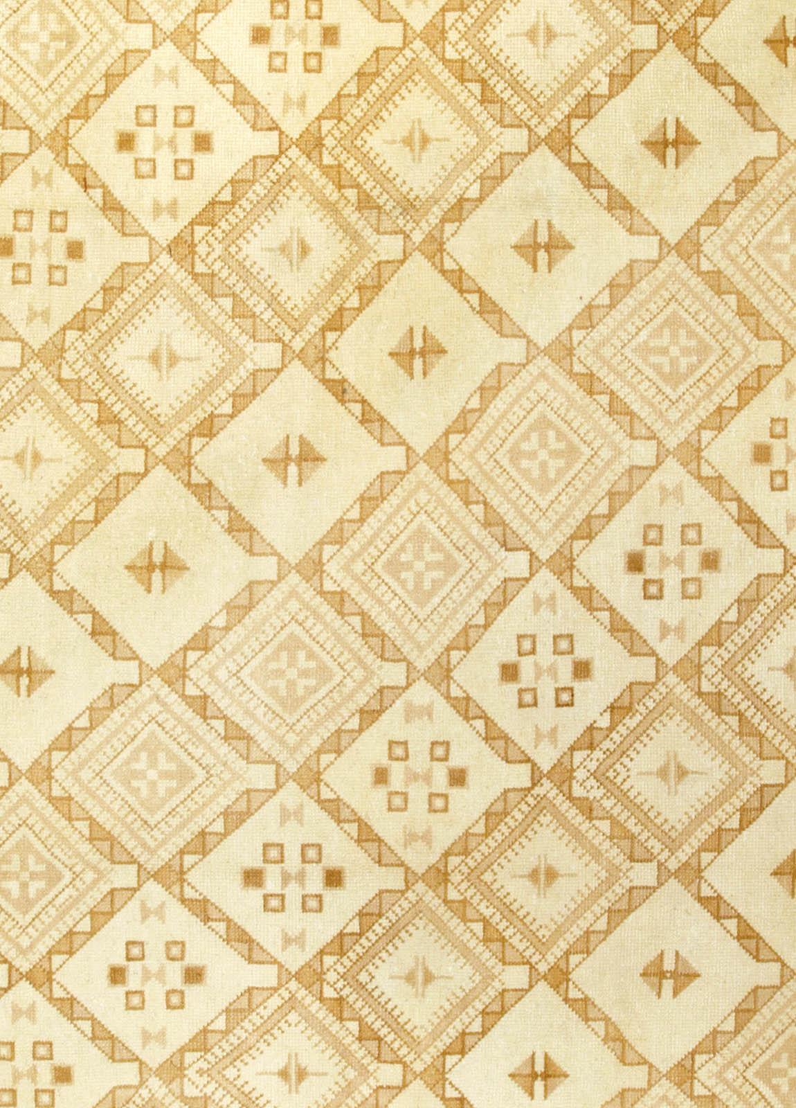Vintage Moroccan beige hand knotted wool rug
This striking vintage Moroccan carpet features an all-over latticed field in shades of yellow, beige and brown. The intricate geometric shapes detailing the outlines of the lattice create somewhat of an