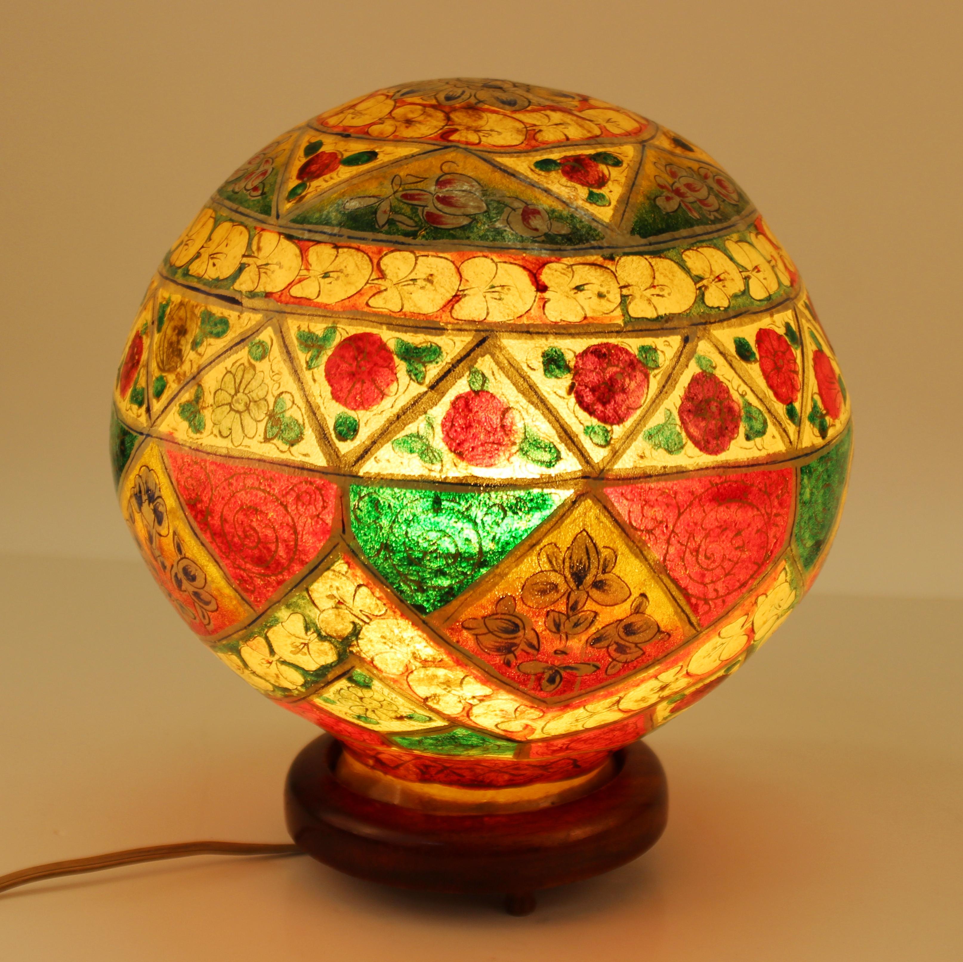 Moroccan midcentury period hand painted camel skin table lamp. The spherical shaped lamp has a profusion of hand painted tribal motifs and comes off the wooden base to access the bulb. In great vintage condition with age-appropriate wear to the