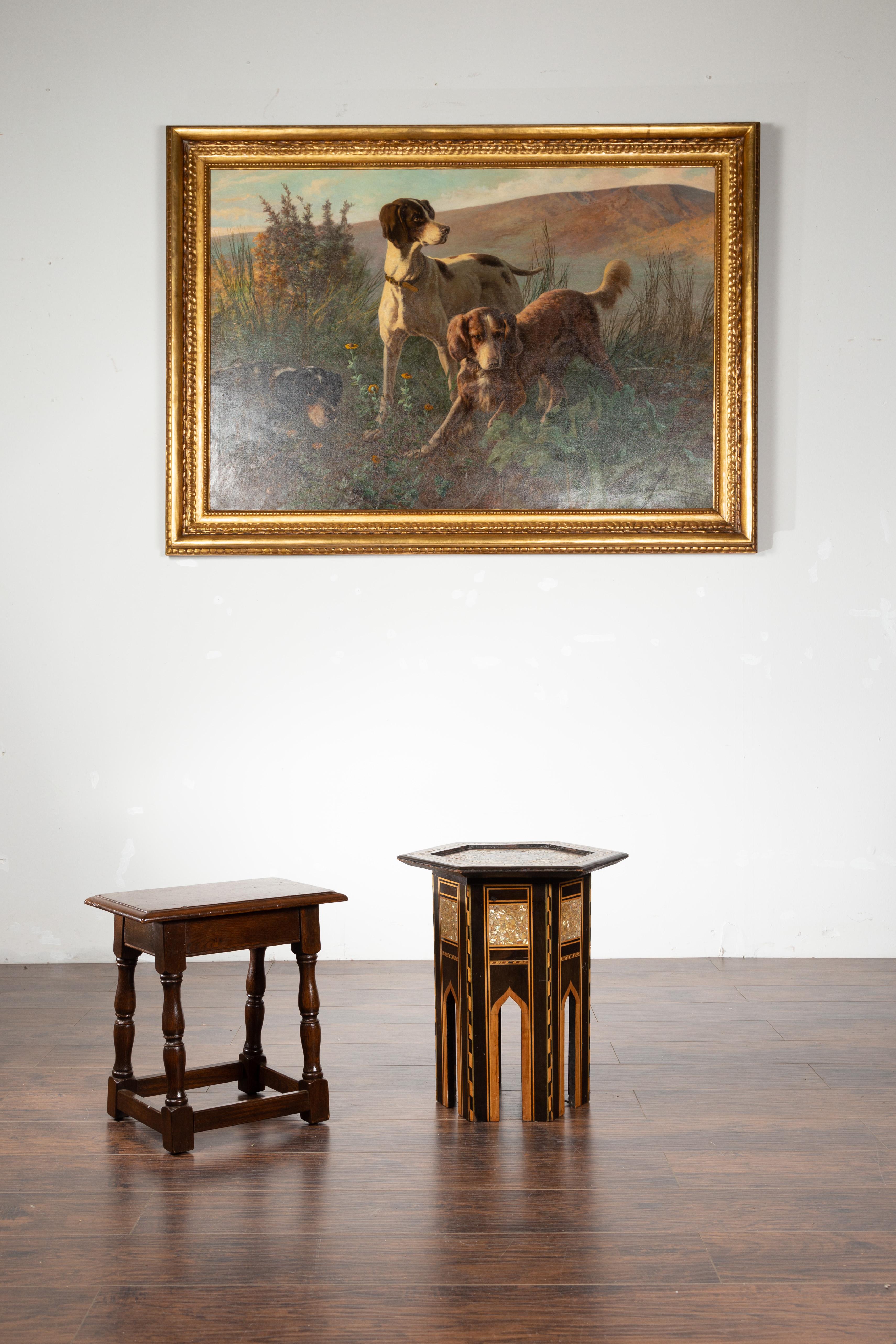 A Moroccan side table from the mid 20th century, with inlaid star motif. Created in Morocco during the midcentury period, this side table features an hexagonal top adorned with a large inlaid star surrounded by mother-of-pearl accents. Each panel of