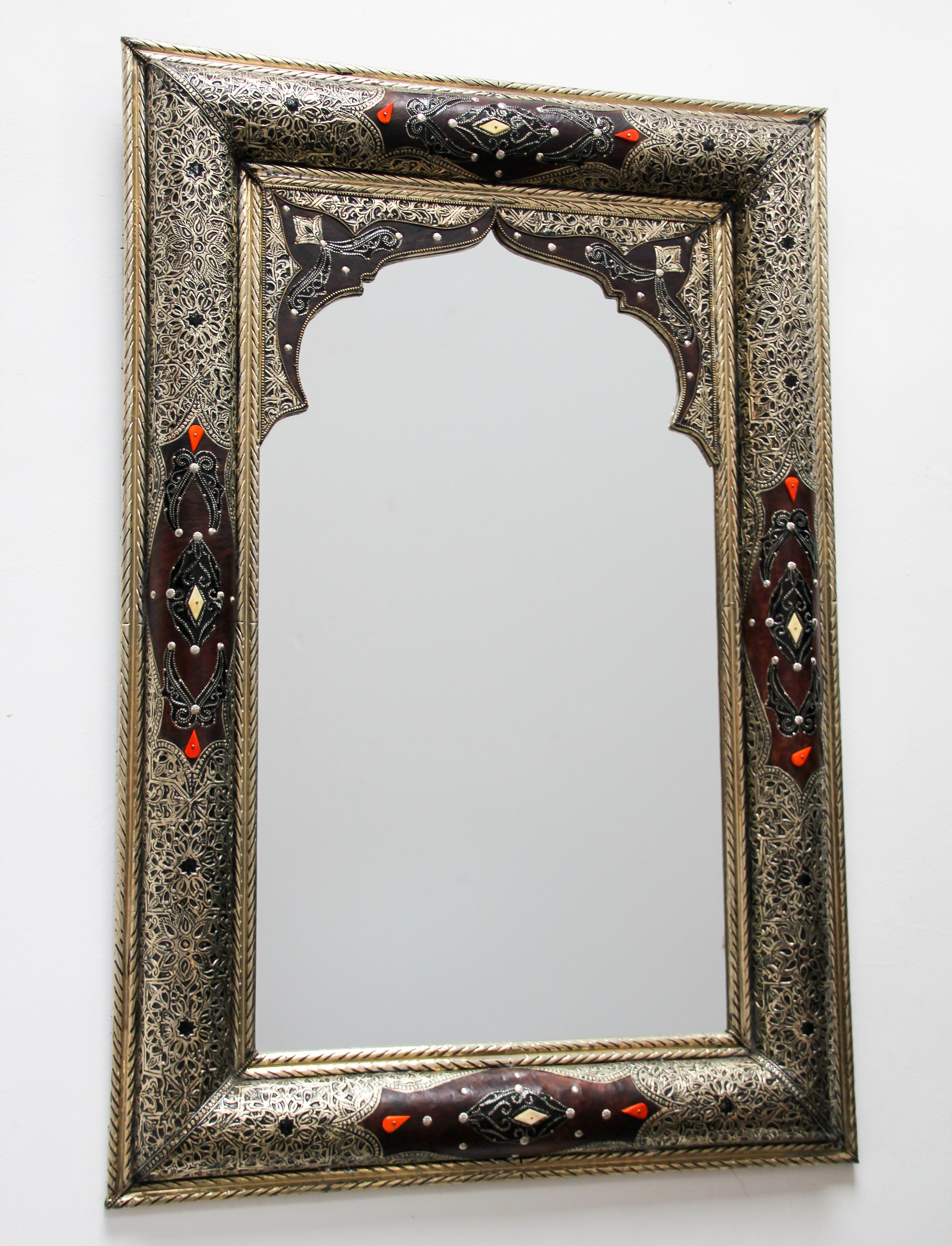 Elegant Moroccan mirror decorated with silvered repousse metal delicately engraved and wrapped with leather and amber color stones.
The inside mirror has a Moorish arch in leather and fine filigree silver décor.
Handcrafted rectangular Orientalist