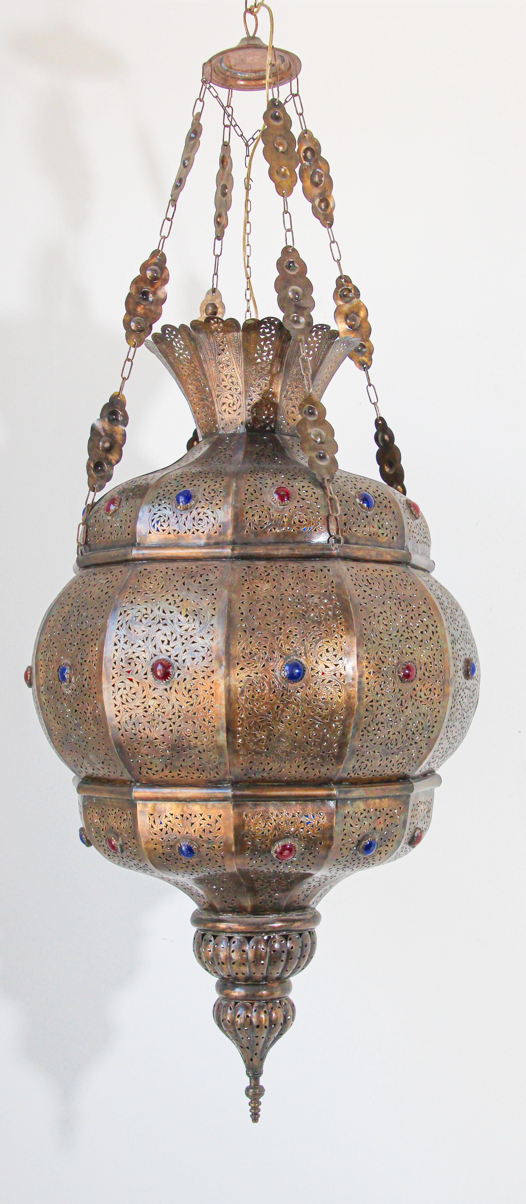 Eleganter marokkanischer Granada-Kronleuchter im maurischen Stil aus Messing mit farbigen Glaseinsätzen.
Handgefertigt in Marokko mit sehr feinem, filigranem, durchbrochenem Messingdesign und Intarsien aus farbigem, mit Edelsteinen besetztem