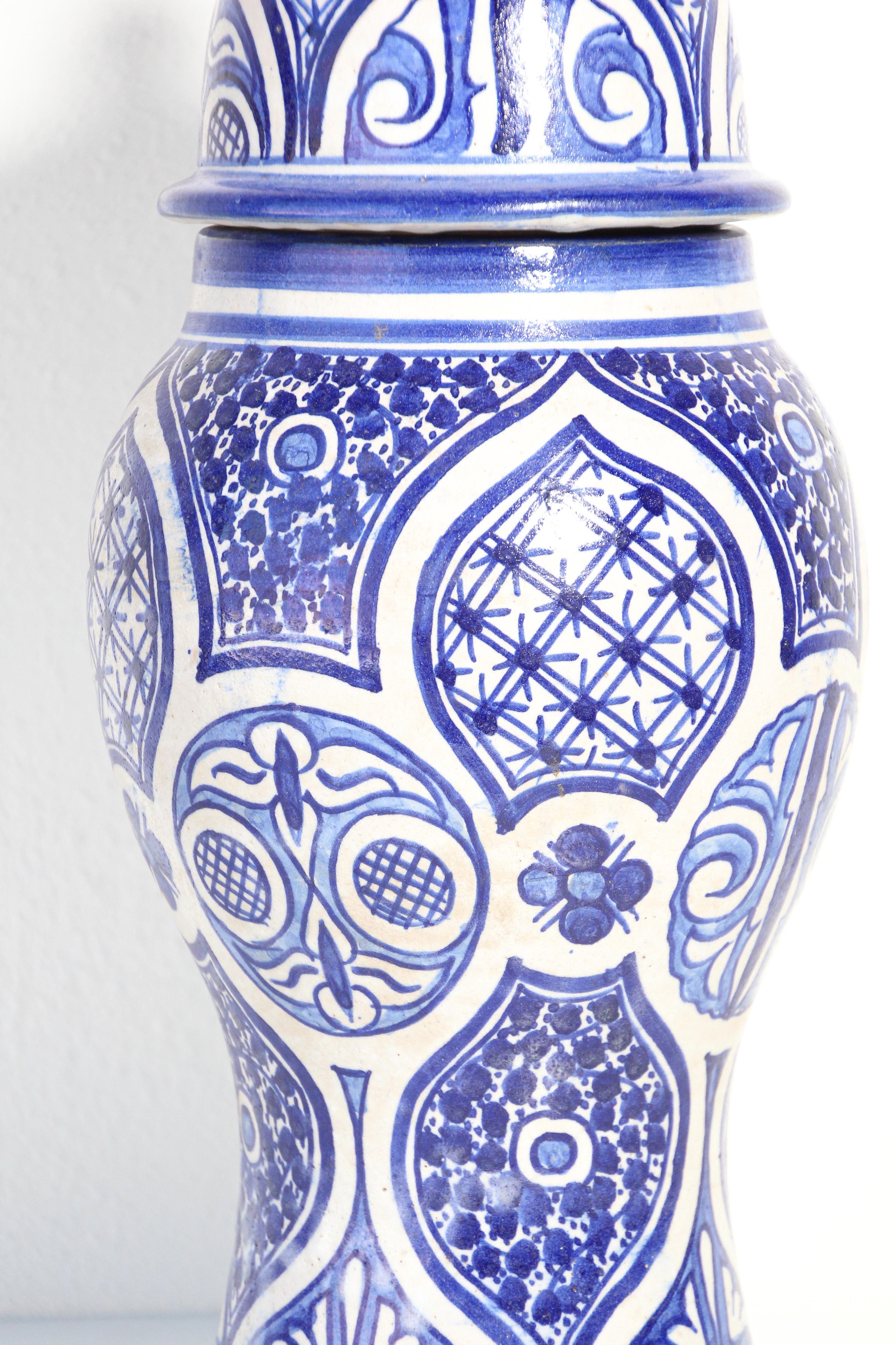 Decorative Moroccan glazed ceramic jar with lid from Fez.
Moorish style decorative ceramic urn handcrafted and hand painted floral design.
Royal blue and ivory color Moorish design.
Size: 16 in. height x 7 in. diameter.
Great to use as ceramic