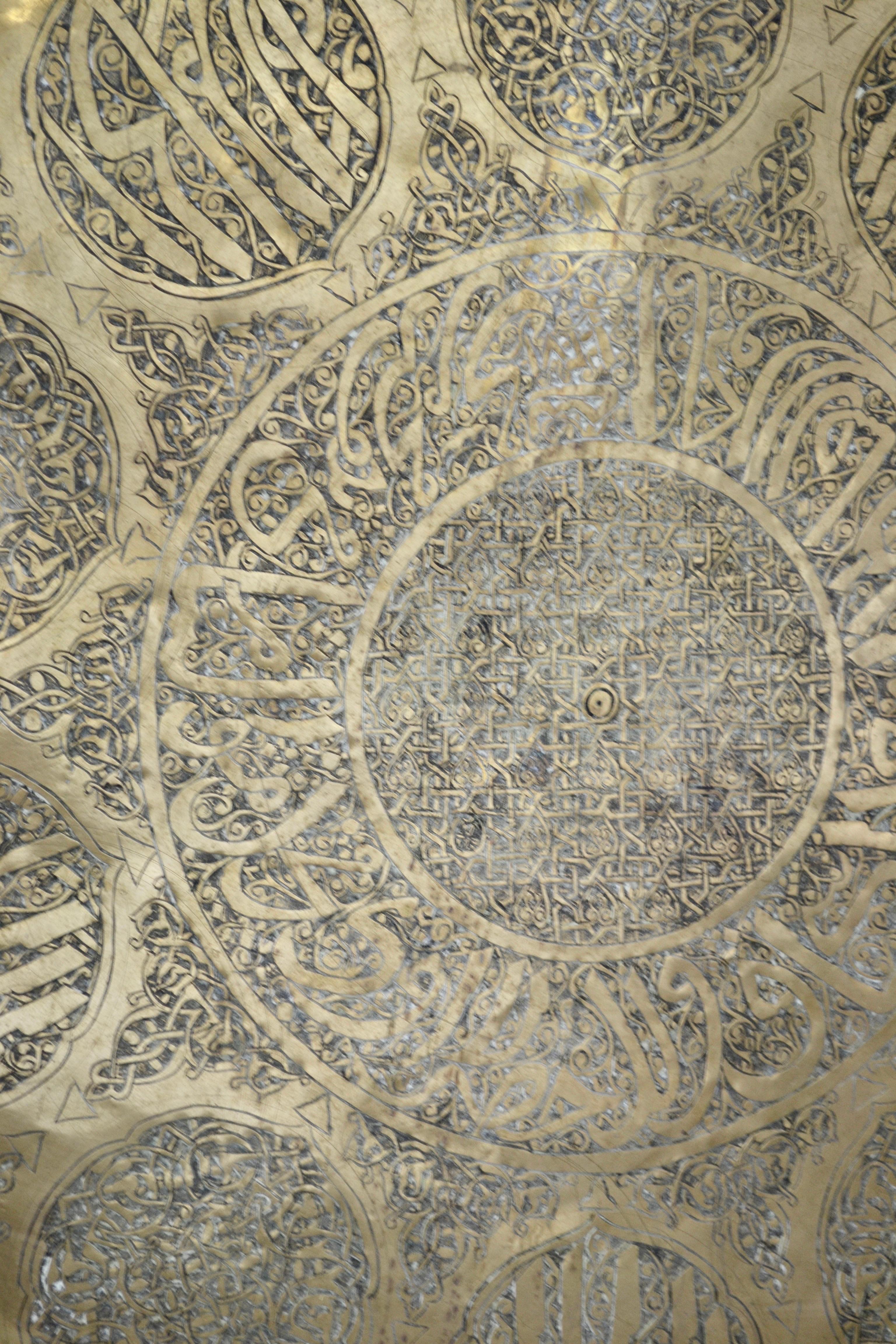 An exceptional Moorish Moroccan folding tray table, featuring a beautifully hand-hammered round copper top resting on an intricately hand-carved wooden base.

The removable tray is richly adorned with geometric and arabesque motifs, hallmarks of