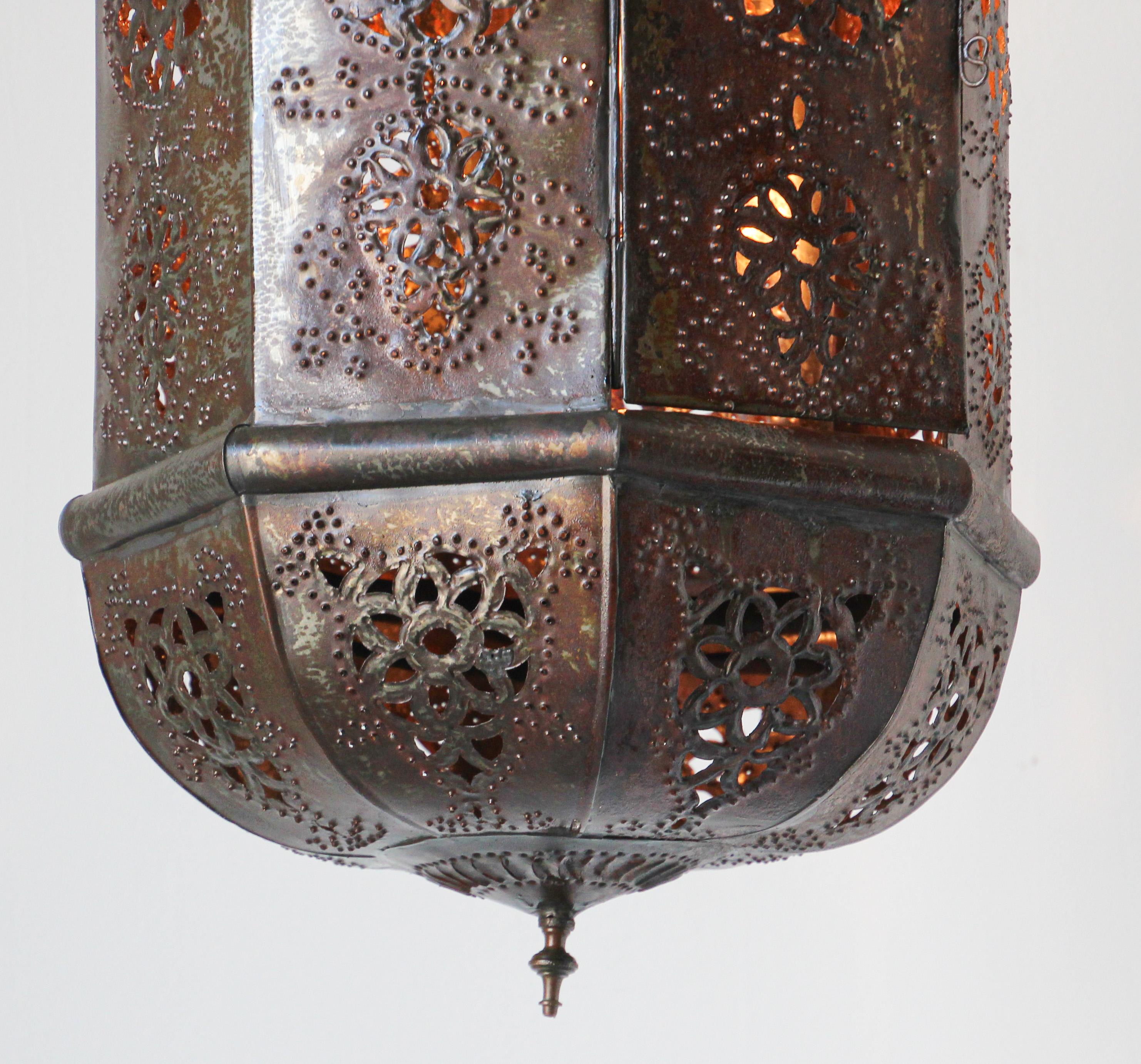 Moroccan handcrafted metal lantern pendant.
Amazing Moorish light fixture hand-pierced with thousands of small holes to diffuse the light through.
Handmade of metal open work with dark bronze rust patina.
Very light metal lantern.
Handcrafted by