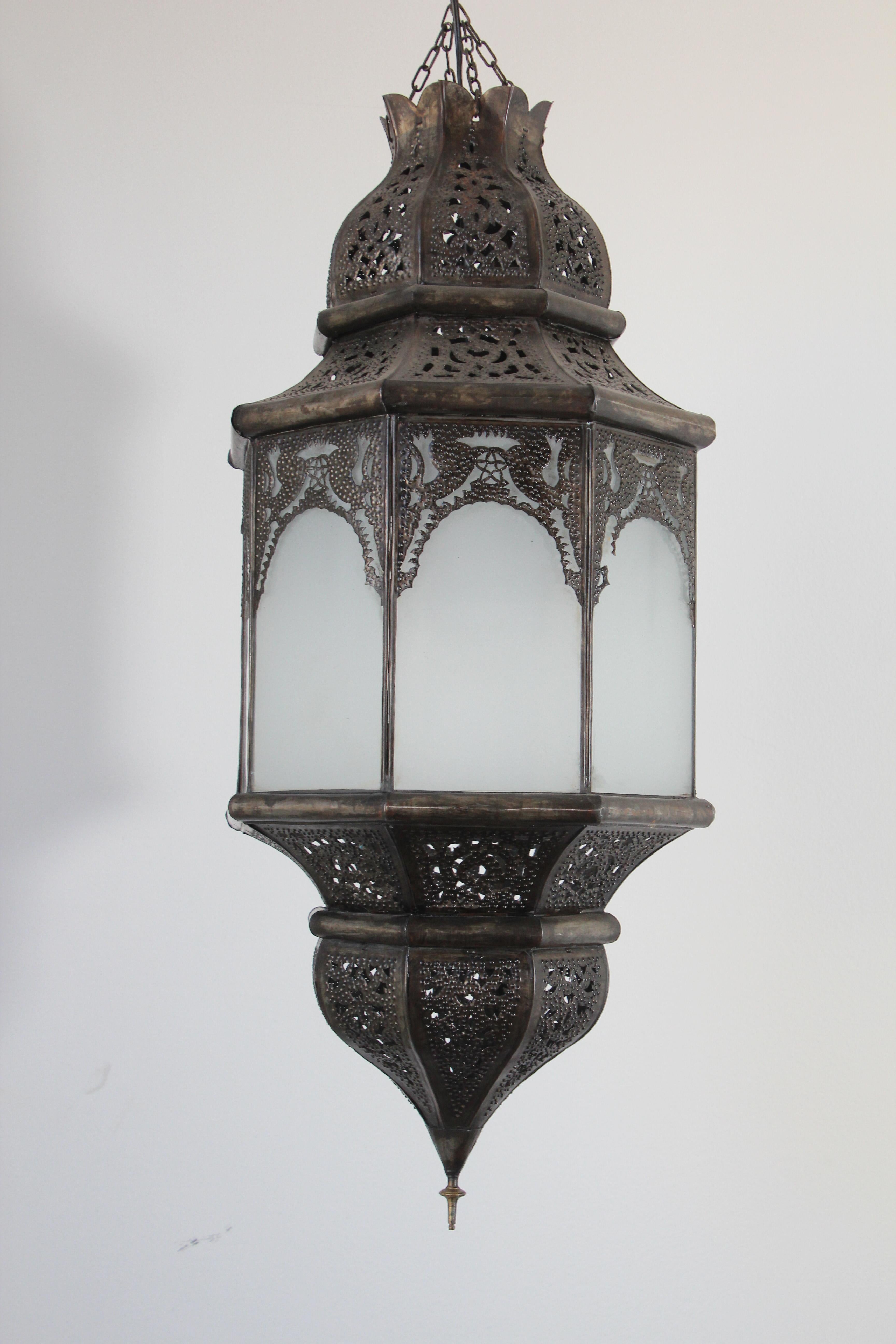 Vintage large Moroccan Moorish hanging glass pendant from Marrakech with sandblasted glass in white milky glass with dark bronze color metal finish.
The Moroccan lantern has been rewired and has a small door on the side to change the light