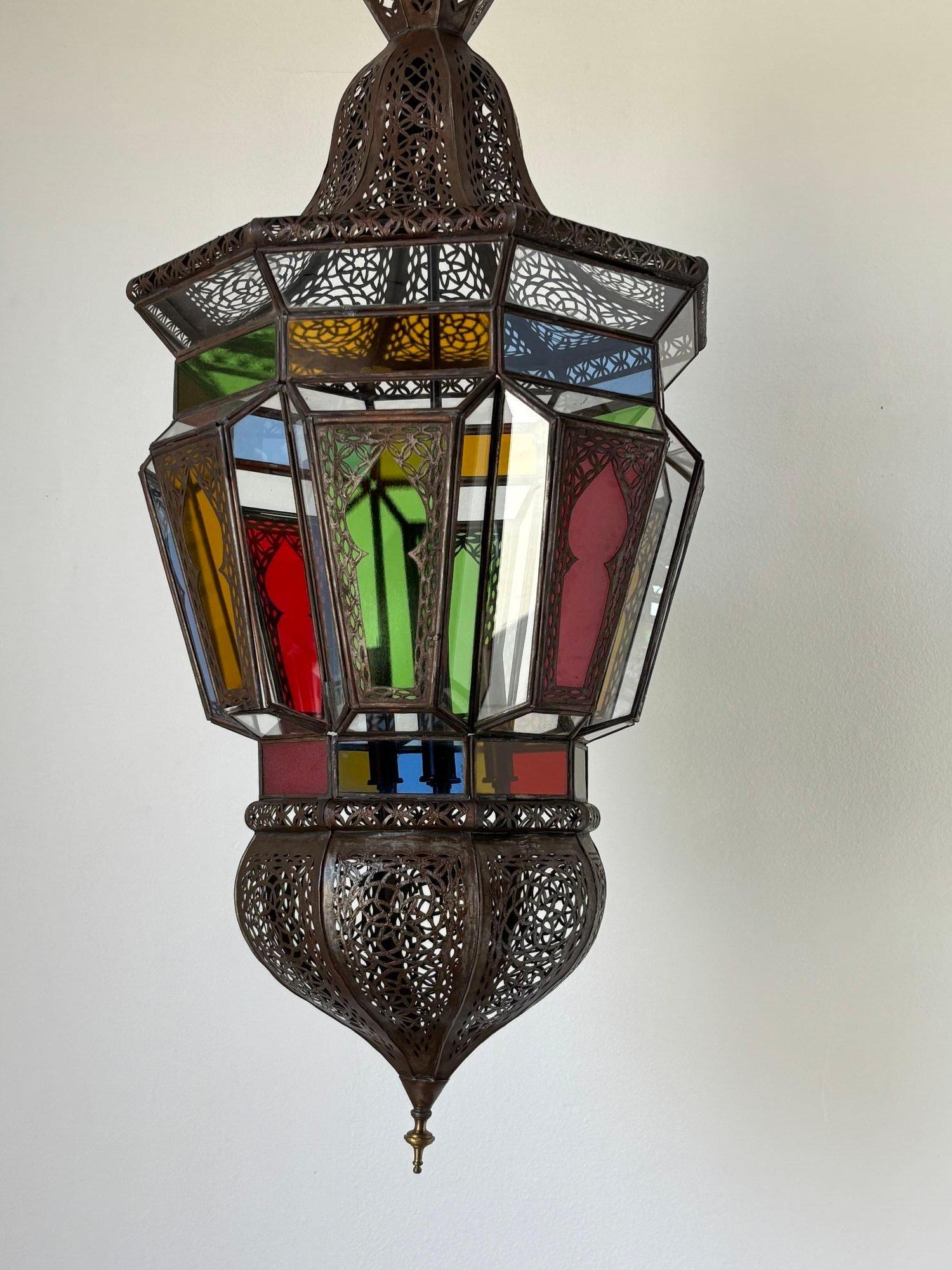 Moroccan Moorish vintage clear glass with intricate metal filigree hanging chandelier.
The Moroccan lantern has been rewired in the US with a cluster of 4 candelabra lights.
Delicately hand-made by artisans in North Africa Morocco and featuring