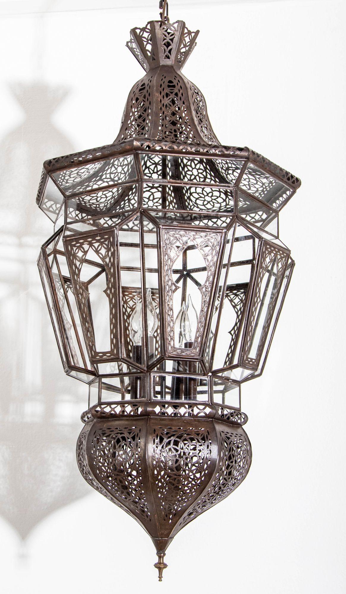 Moroccan Moorish vintage clear glass with intricate metal filigree hanging chandelier.
The Moroccan lantern has been rewired in the US with a cluster of 4 candelabra lights.
Delicately hand-made by artisans in North Africa Morocco.
Bronze metal