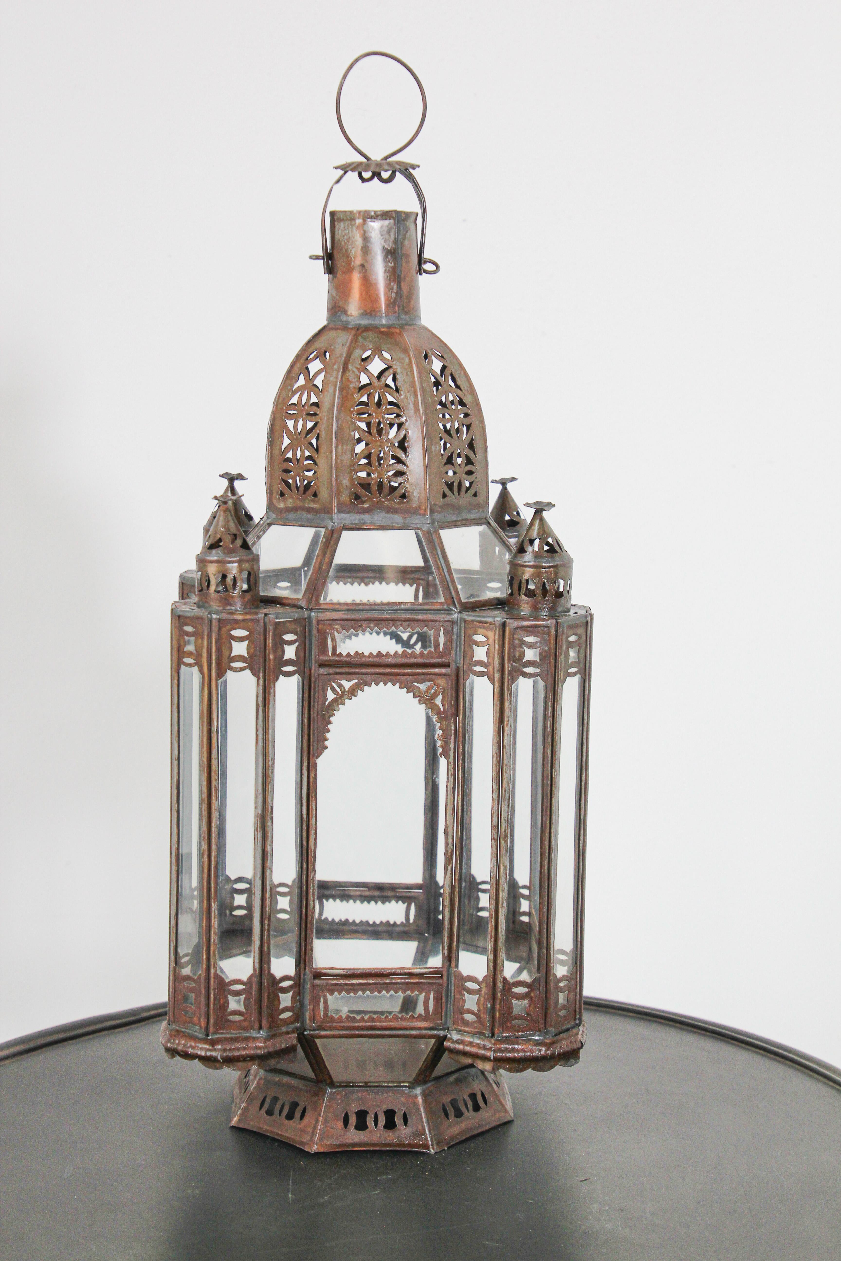 Handcrafted Moroccan metal clear glass lantern or Moorish pendant.
Hurricane candle lamp handmade in Marrakech, vintage metal in rust color finish.
Nice Moorish shape, could be used as a candle lantern on a table, hanging from a tree or as a