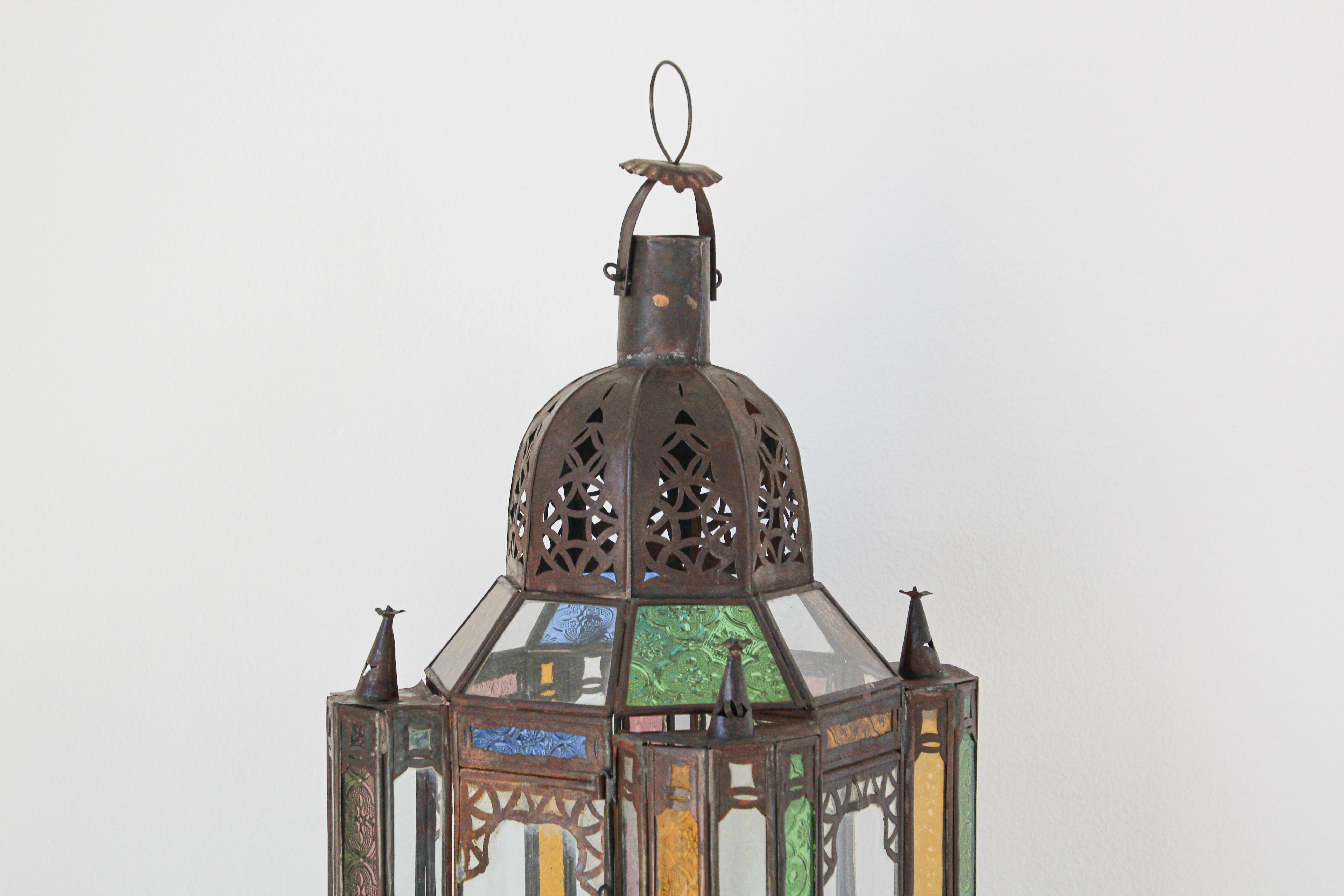 Handcrafted vintage Moroccan metal glass lantern or Moorish pendant.
Moorish style North African lantern with multi-color molded colored glass panels in green, lavender, blue and clear.
Hurricane candle lamp handmade in Marrakech, vintage metal in
