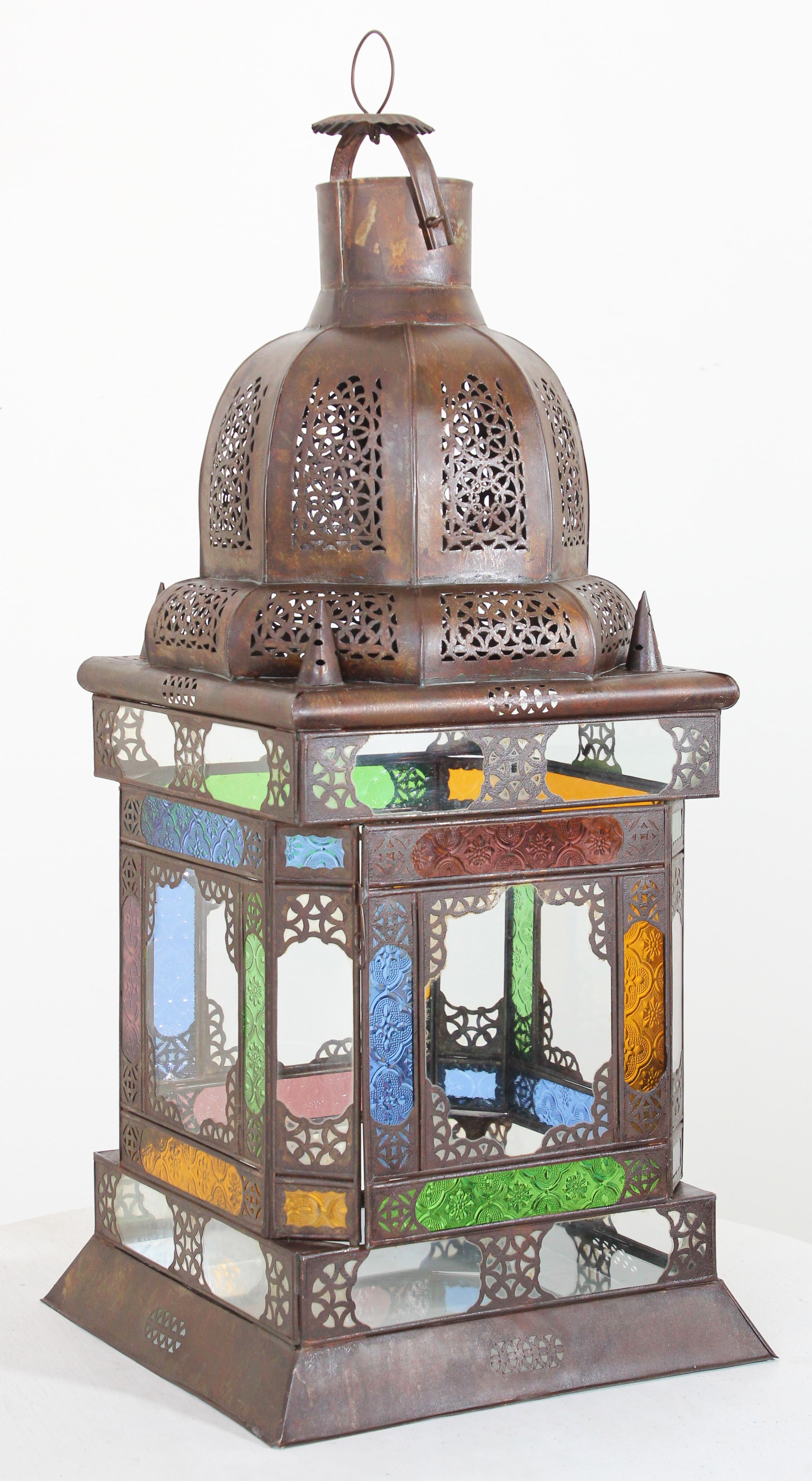 Vintage Moroccan metal lantern with multicolor glass.
Large glass Moroccan lantern with Moorish design.
Square shape elegant impressive intricate pierced metal and glass Moroccan Lantern,
29 inches tall with clear, blue, green, red and gold blown