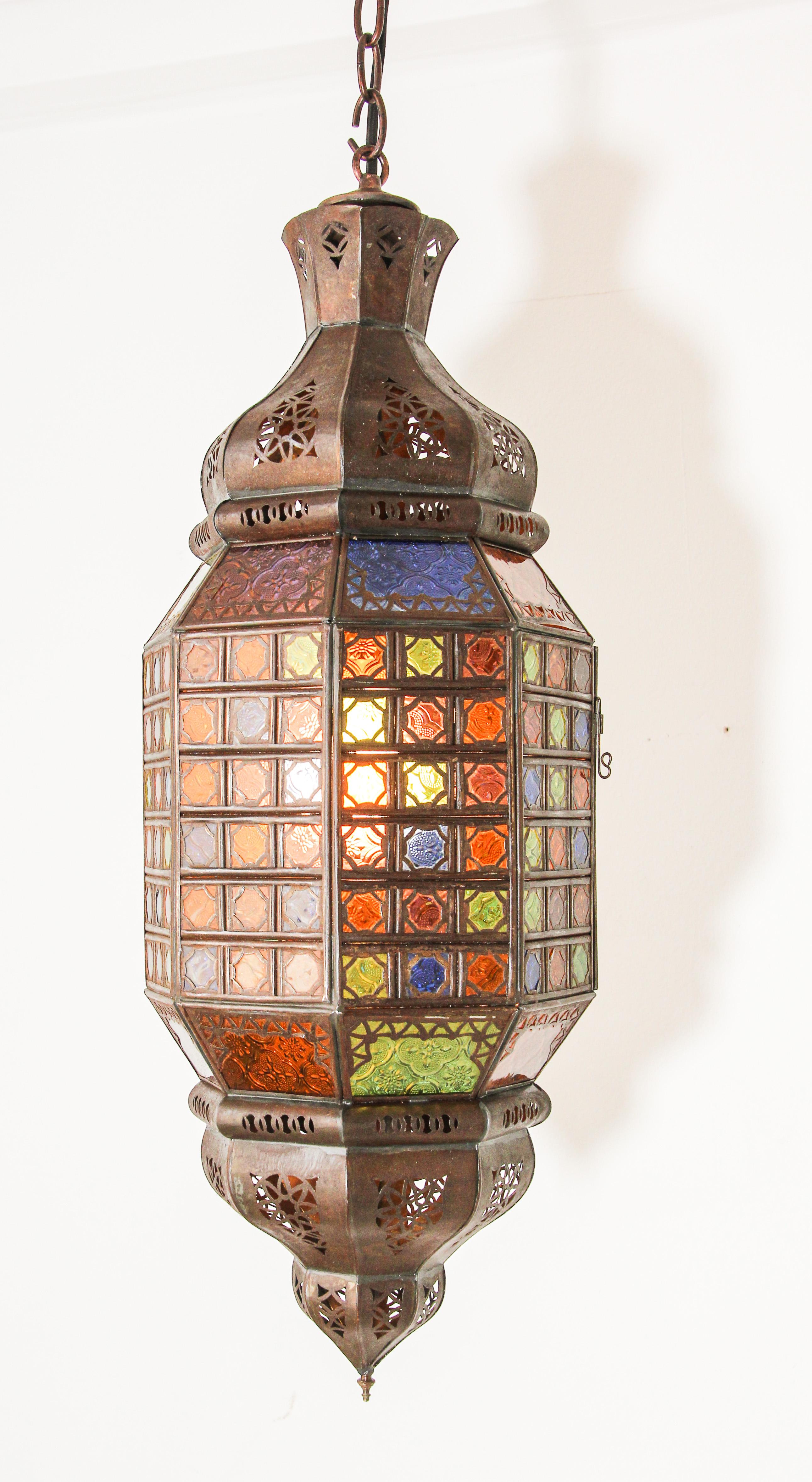 Stylish handcrafted Moroccan pendant light fixture with multi-color molded Moorish glass and metal with an antique rust finish.
Bohemian style metal and glass lantern with dozens of small cut-glass with Moorish openwork filigree metal design in
