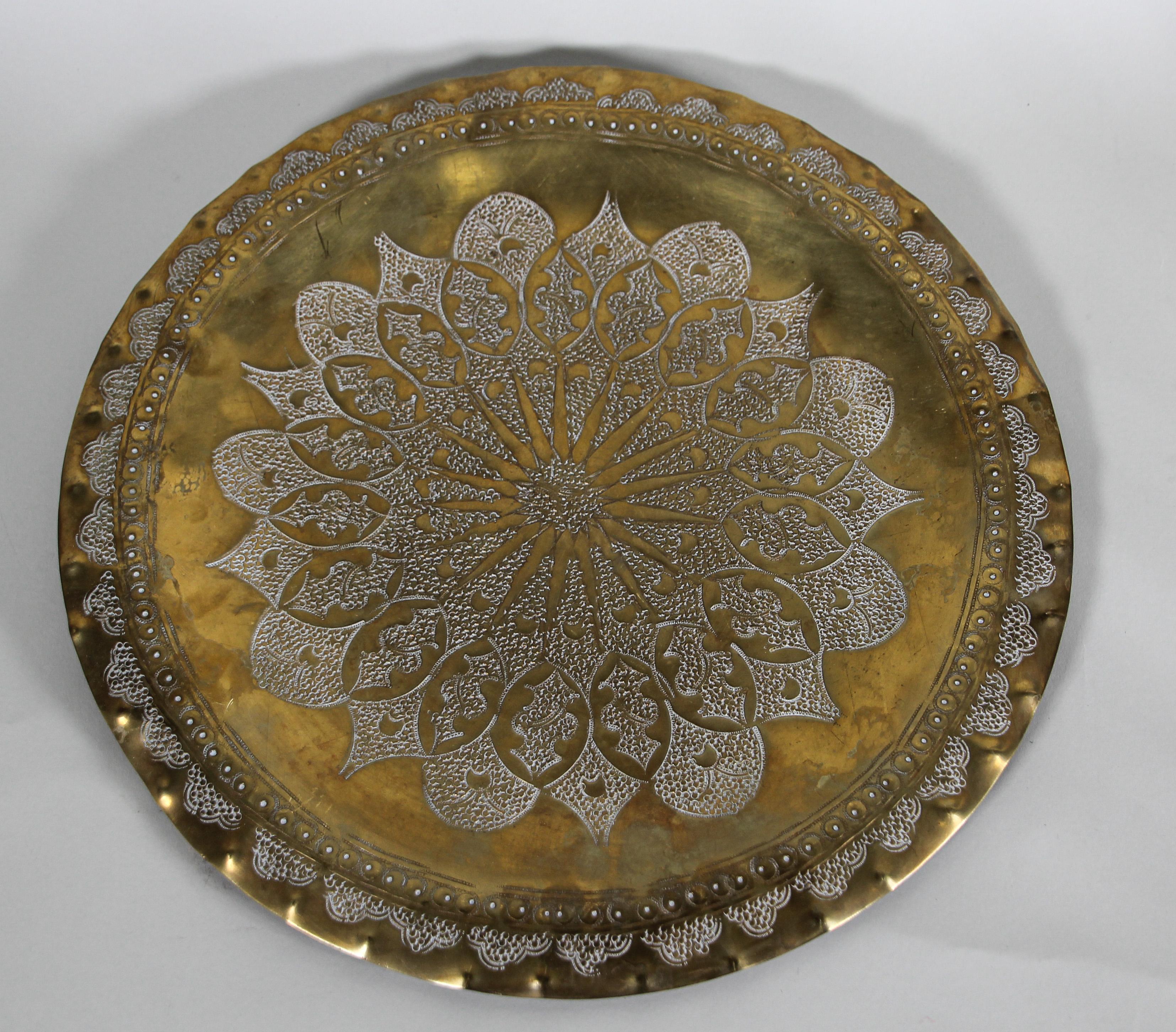 Moroccan circular tray hammered with Moorish geometric design.
Metal brass with very fine hand chased floral and geometric and floral stylized Arabic designs.
Could be used as a decorative brass plate, or as serving tray.
Hand-hammered decorative