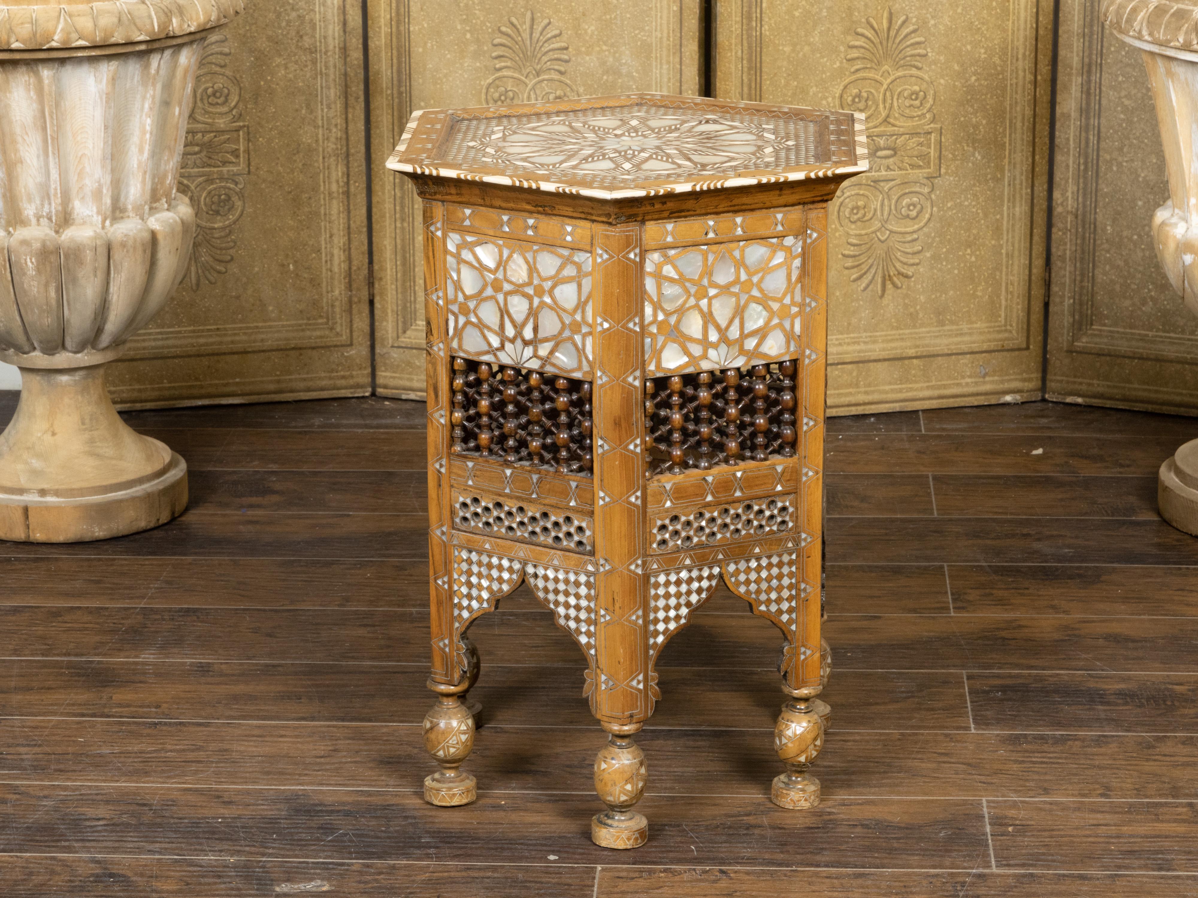 A Moroccan Moorish style drinks table from the early 20th century, with mother-of-pearl inlay, hexagonal top, geometric décor, turned balusters and carved pierced motifs. Created in Morocco during the first quarter of the 20th century, this petite