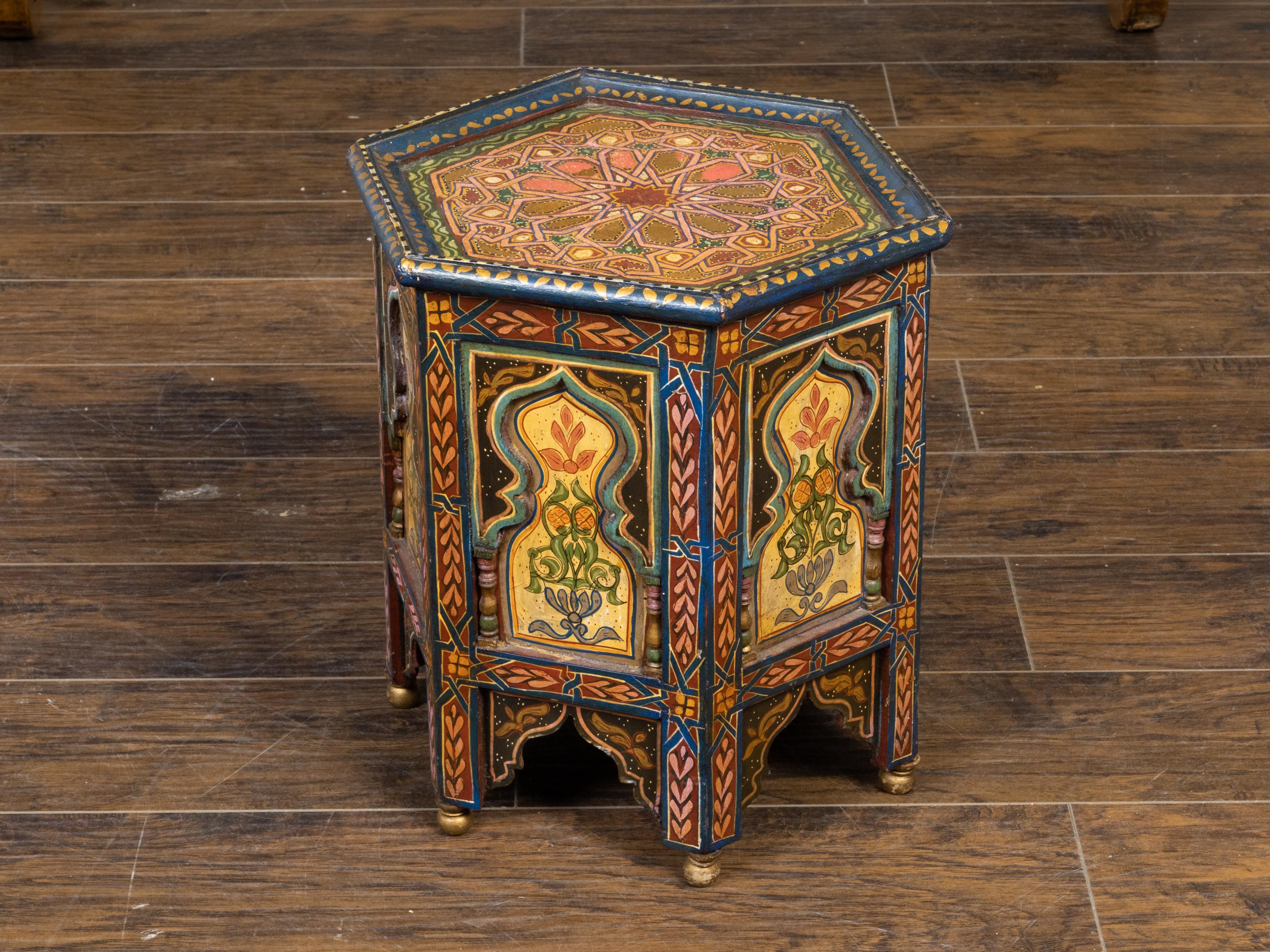 Tavolino in stile moresco marocchino dei primi del Novecento, con motivi geometrici dipinti, piano esagonale, decorazioni policrome e motivi fiammeggianti intagliati. Creato in Marocco nel primo quarto del XX secolo, questo tavolino cattura la