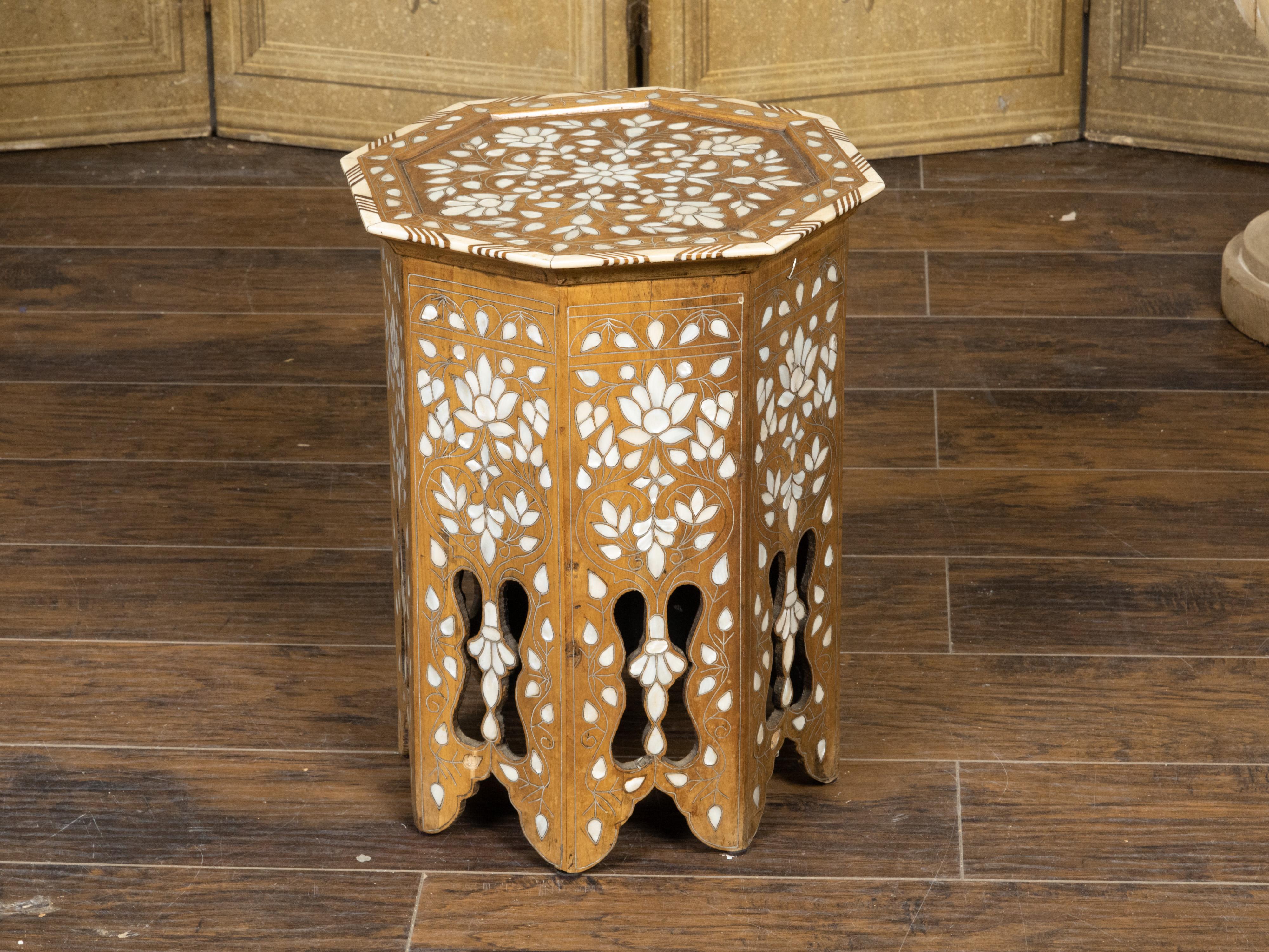 A Moroccan Moorish style drinks table from the early 20th century, with mother-of-pearl inlay, octagonal top, floral décor and carved base. Created in Morocco during the first quarter of the 20th century, this petite side table captures our