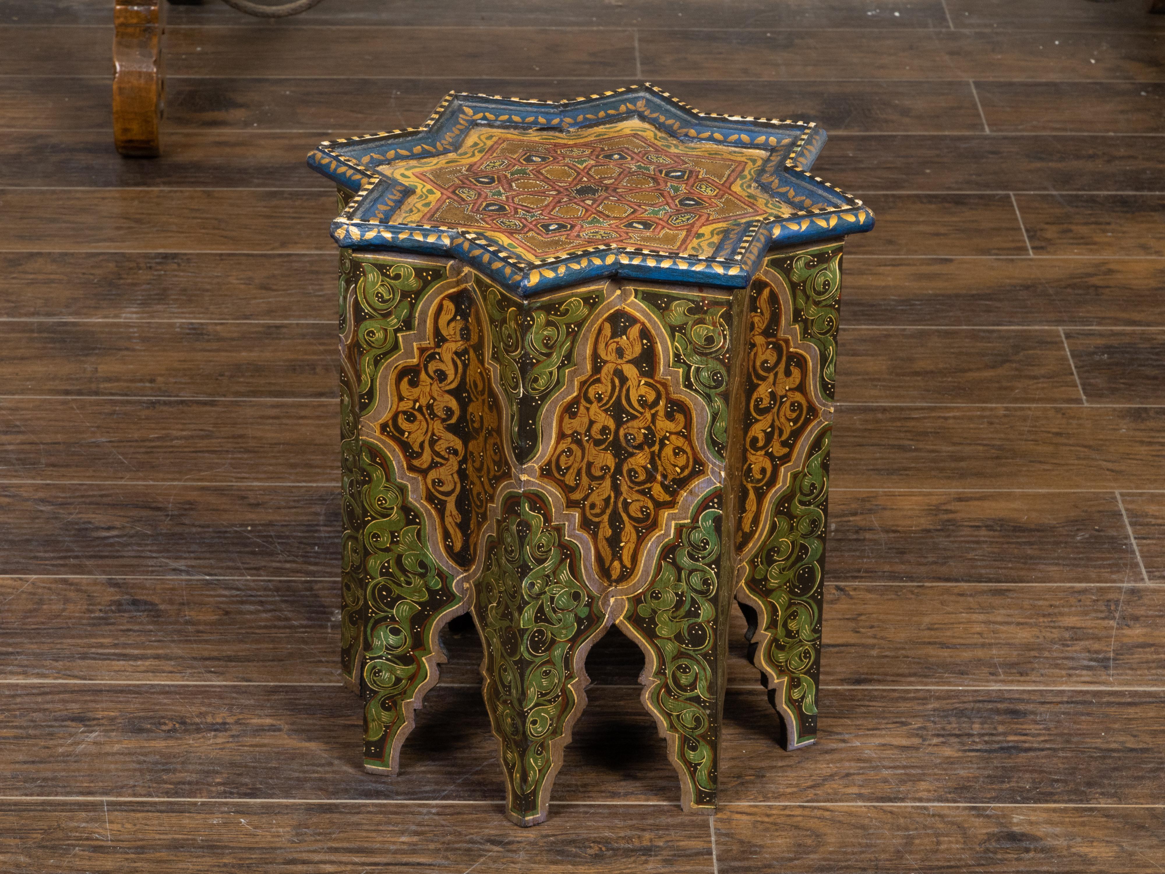 A Moroccan Moorish style drinks table from the early 20th century, with star-shaped top, octagonal body, polychrome décor and carved flaming feet. Created in Morocco during the first quarter of the 20th century, this petite side table captures our