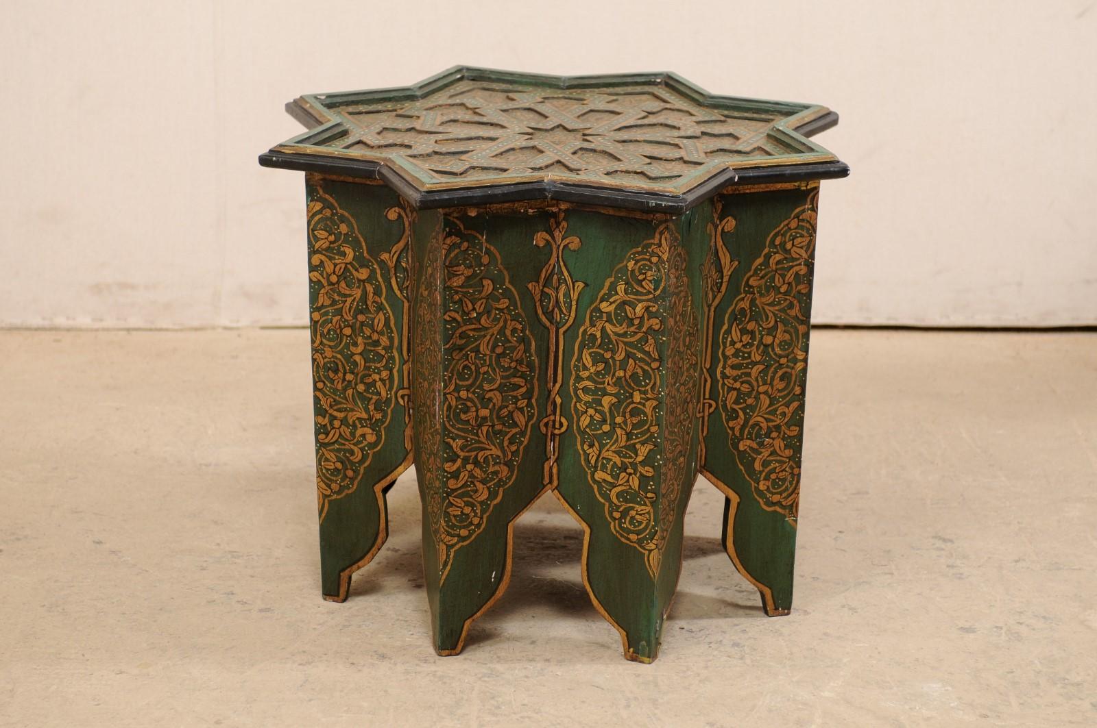A vintage Moroccan small coffee or tea table delicately hand-painted with Morrish star-shaped top. This side table from Morocco features a Morrish star-shaped top, with recessed cut-outs in geometric and star shapes, set within raised lip about