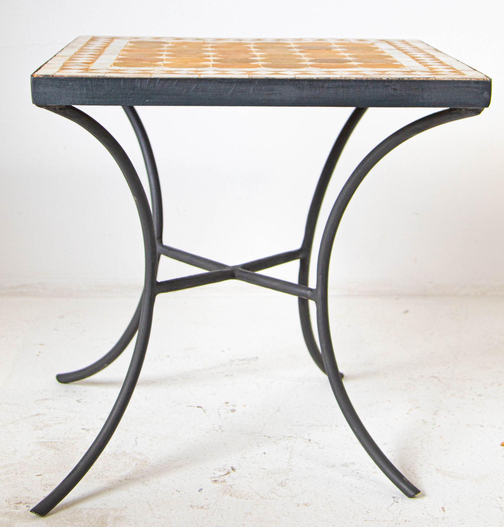 Vintage Moroccan mosaic tile square table on iron base.
Handmade by expert artisans in Fez, Morocco, using reclaimed old glazed ivory and tan tiles inlaid in concrete using reclaimed old glazed tiles and making beautiful geometrical designs, the