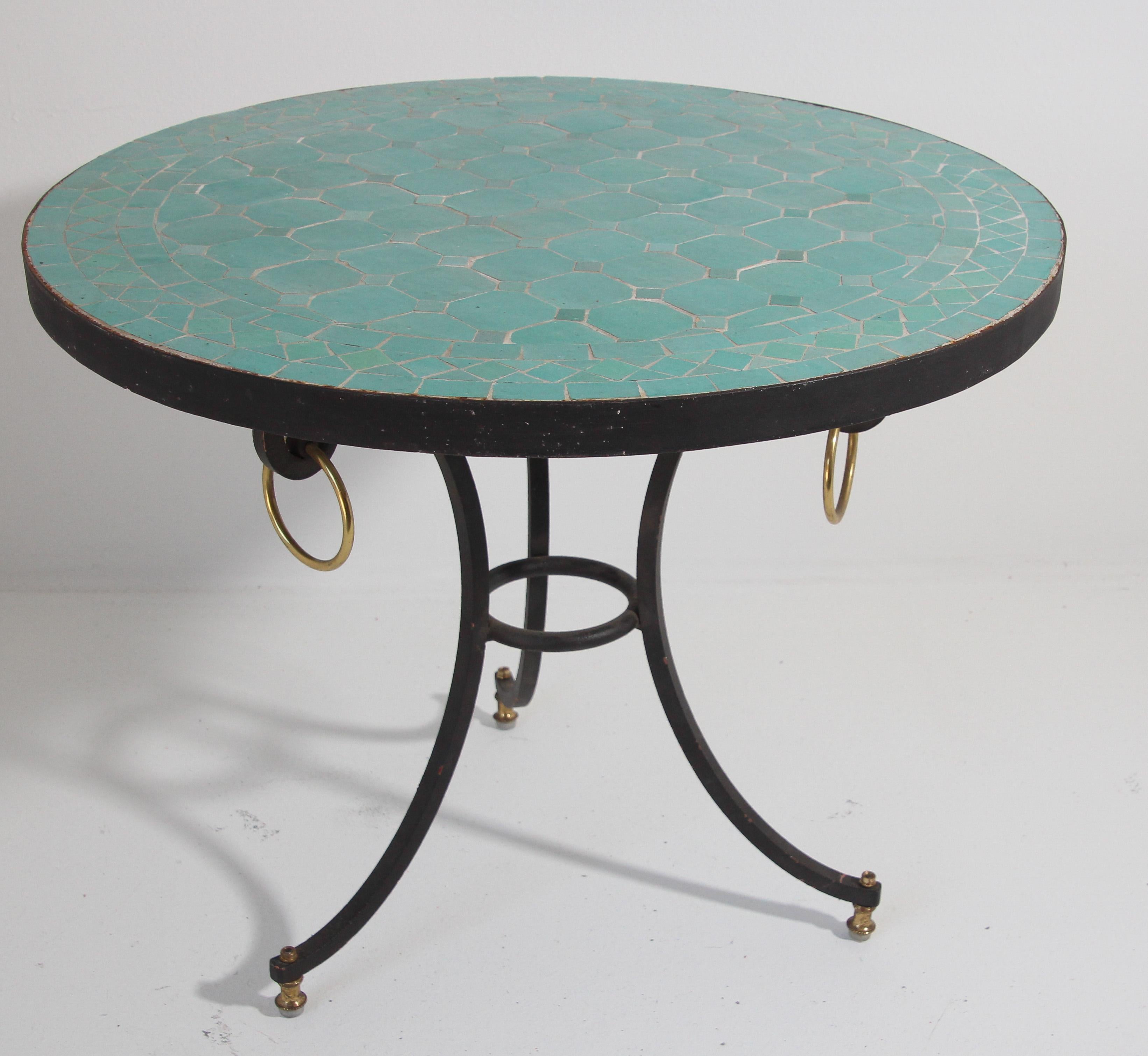 Moroccan mosaic tiles side patio table on iron base.
Handmade by expert artisans in Fez, Morocco using reclaimed old glazed teal color tiles inlaid in concrete using reclaimed old glazed tiles and making beautiful geometrical designs, colors are