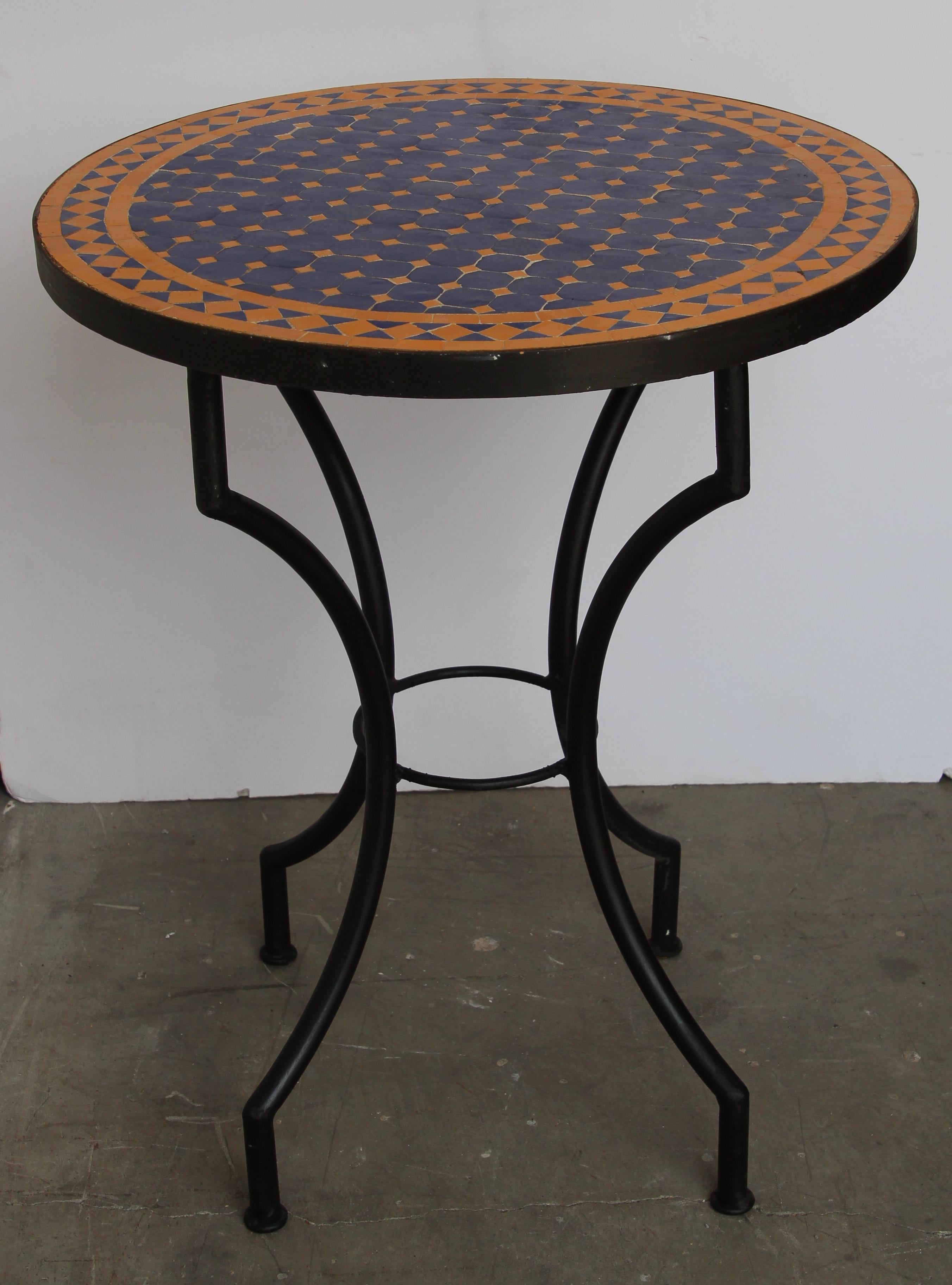 Moroccan mosaic tiles table on iron base.
Handmade by expert artisans in Fez, Morocco using reclaimed old glazed cobalt blue and yellow colors tiles inlaid in concrete using reclaimed old glazed tiles and making beautiful geometrical designs,