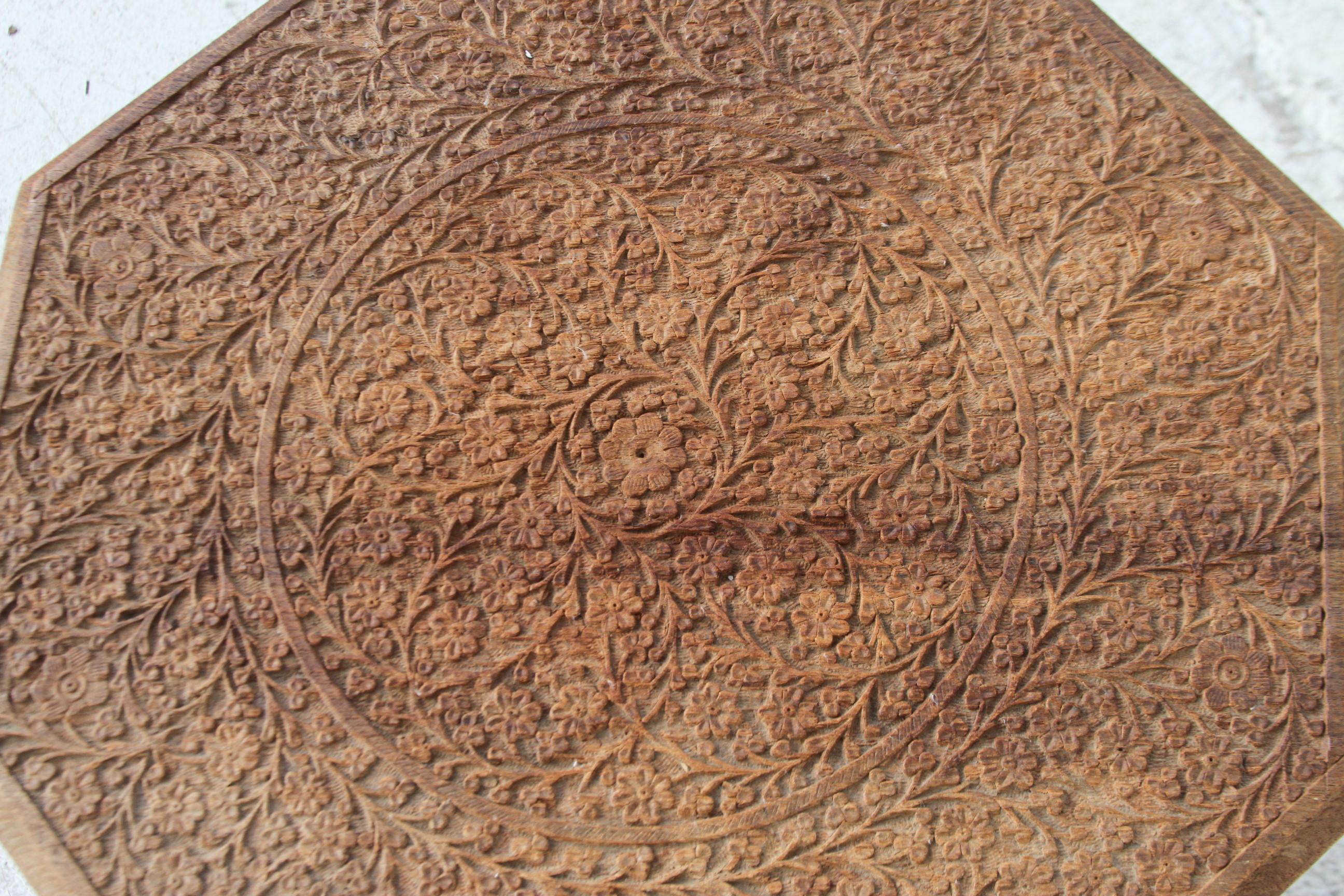 This wonderfully made table comes from North Africa. It has lots of intricate carving on it's corners. The sides are pierced and carved. The octagon top is carved into a beautiful design of flowers. This is a beautiful table and it would make a nice