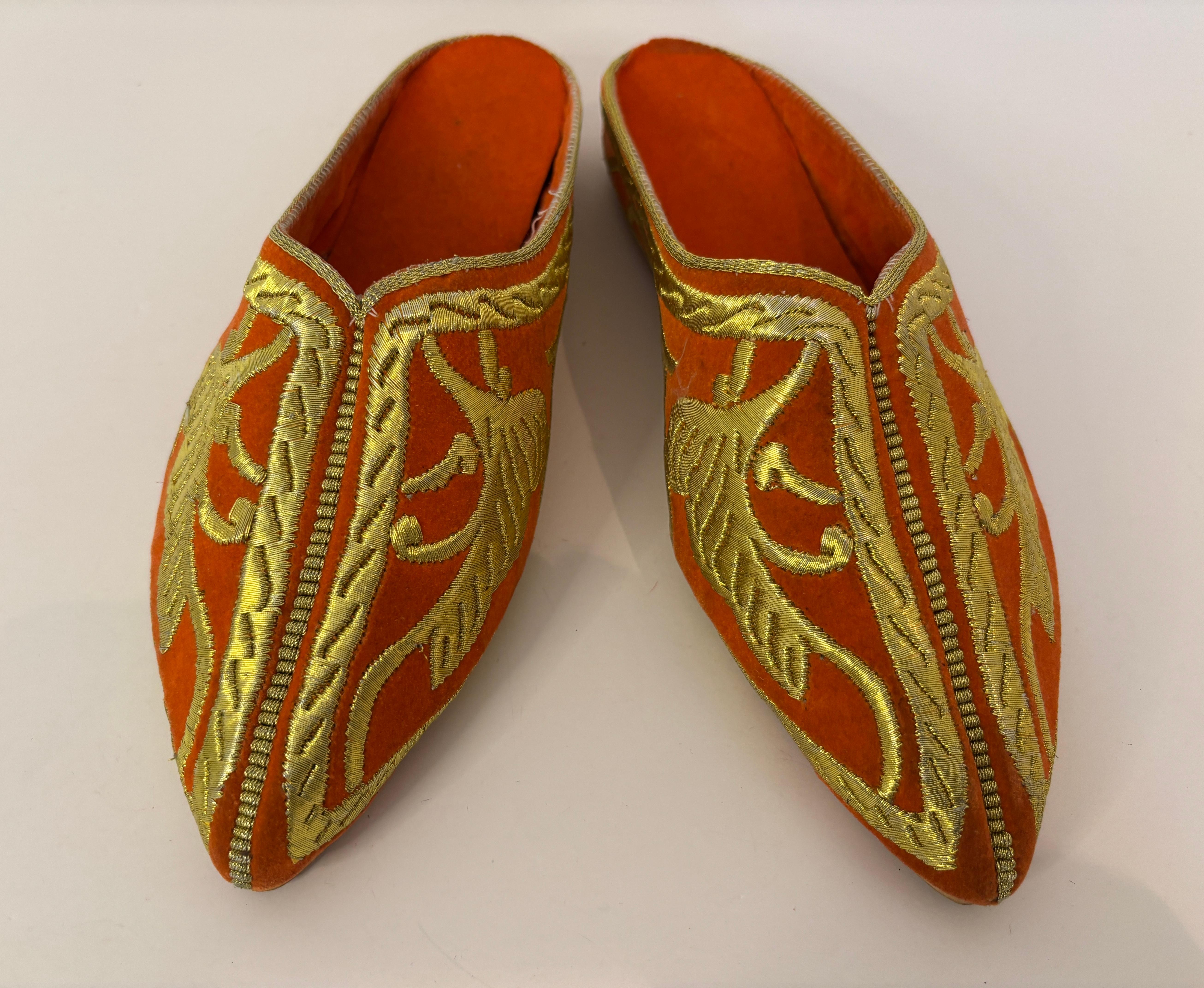 Zapatos moriscos africanos marroquíes de punta bordados en terciopelo naranja vintage.
Chanclas planas étnicas de hilo dorado metálico morisco mogol bordadas del norte de África.
Zapatos ceremoniales de boda de terciopelo decorados con bordados a