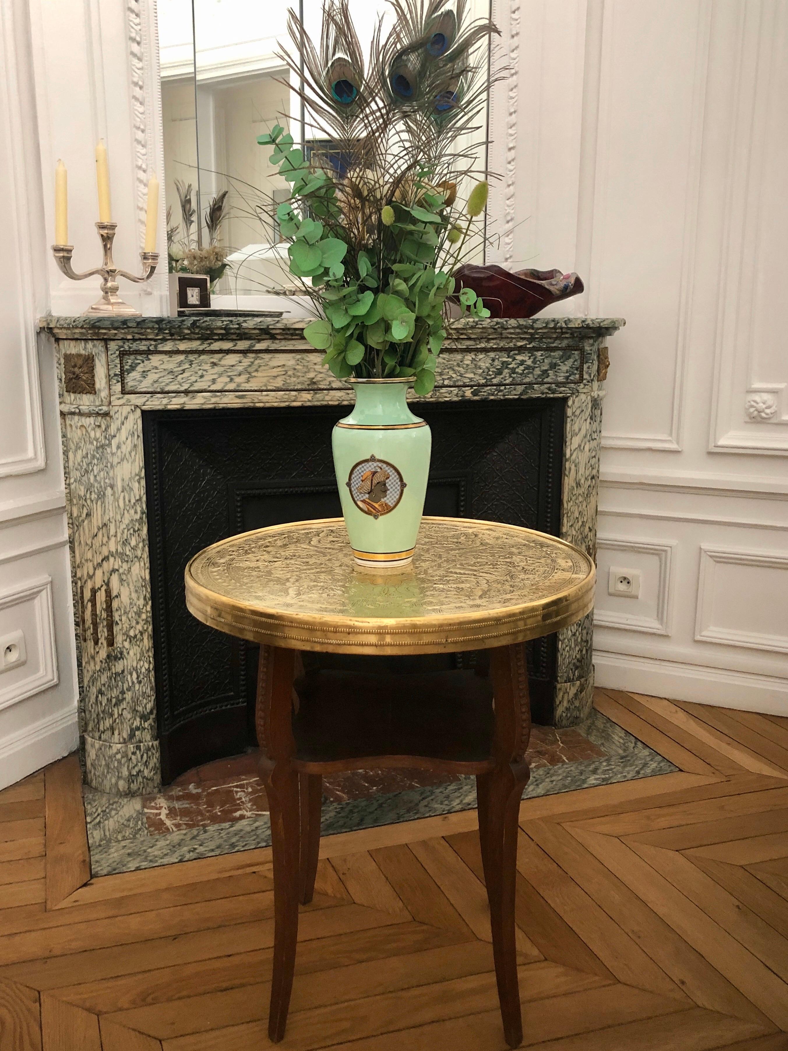 Pedestal table or side table with fixed brass top and elegant wooden base in a stylized form of gazelle legs. The English table from the 1920s in a golden brass is chiseled and hammered by hand with calligraphy cartridges, stars, leaves and