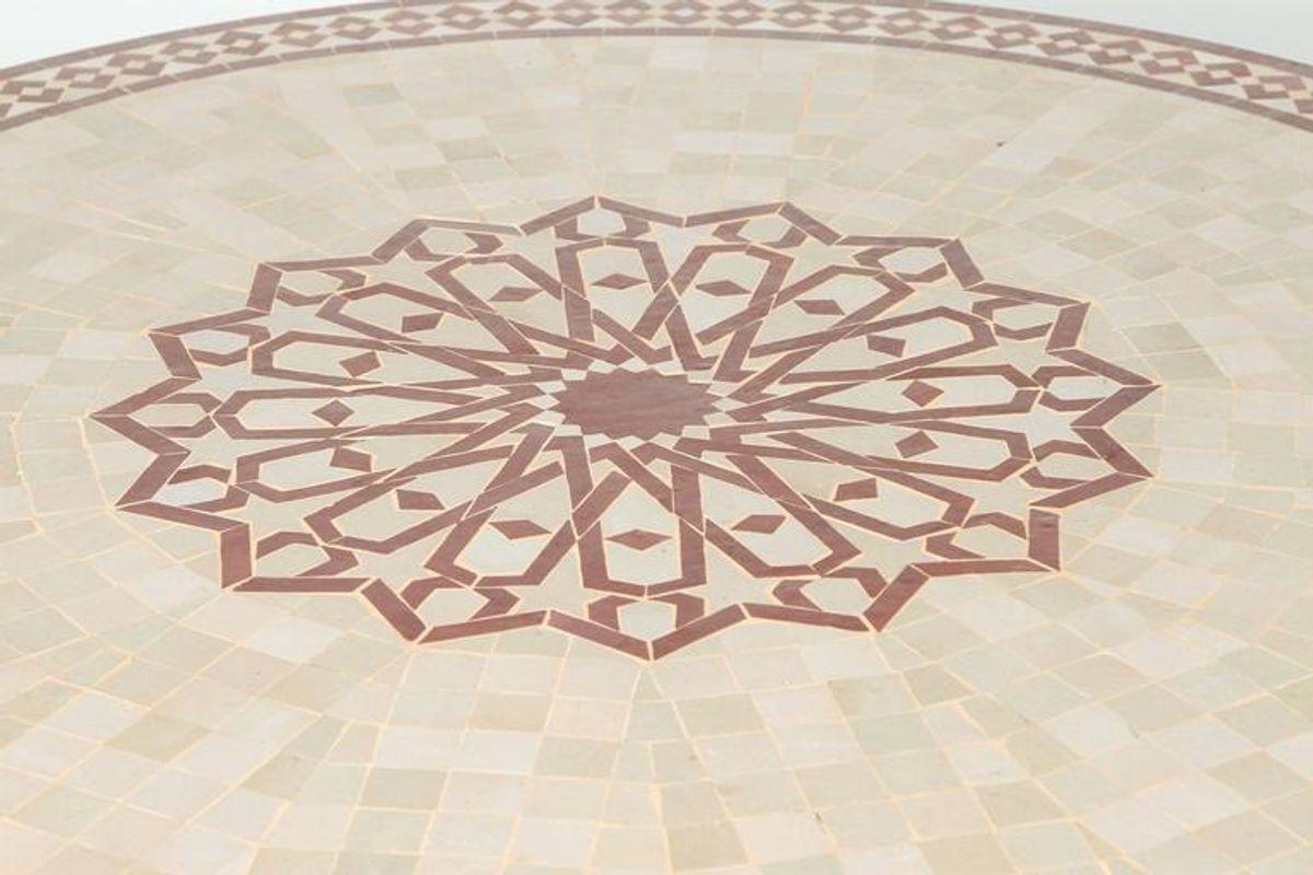 Handcrafted round Moroccan outdoor mosaic tile table 47 in. diameter on iron base. 
Classic and elegant Moroccan outdoor mosaic tile table sit on a black wrought iron base. 
Handmade in Morocco, the artisans from Fez used the classic Moroccan cut