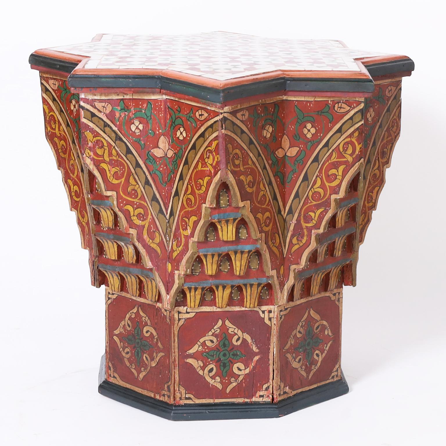 Standout antique Moroccan stand with a star form tiled top over a base paint decorated in distinctive muted mediterranean colors on an octagon form with architectural elements. 