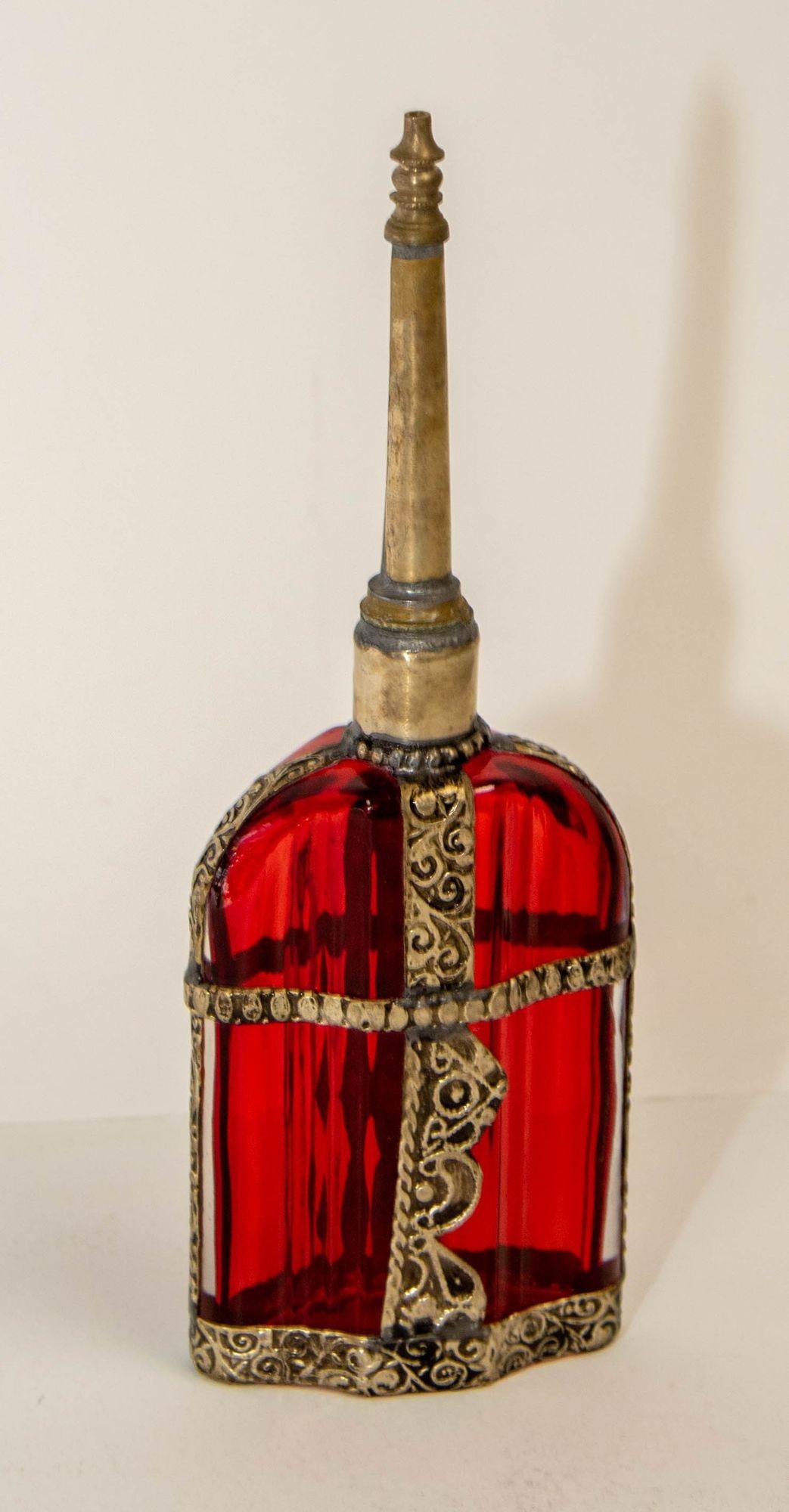 Vintage dekorative marokkanischen roten Glas Parfüm Flasche Sprinkler mit geprägtem Metall-Overlay.
Handgefertigter marokkanischer Parfümflakon aus rot bemaltem Glas oder Rosenwasserzerstäuber mit erhabenem, versilbertem Blumendesign aus Metall über