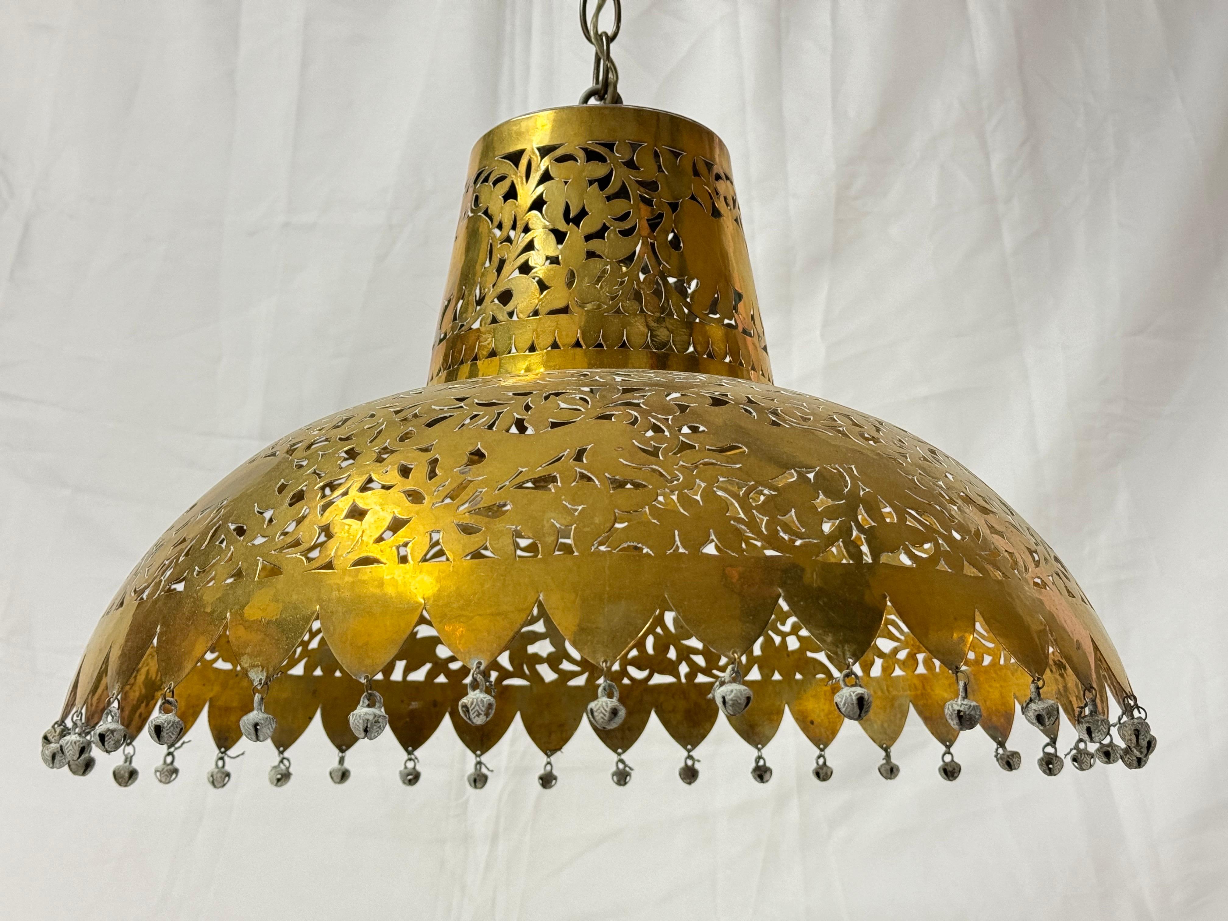  Marokkanischer Kronleuchter aus durchbrochenem Messing. Exotische Pendelleuchte mit Glocken als Verzierungen am äußeren Kreis. Aufwendig geschnitzte Tierfiguren, durch die das Licht reflektiert wird, machen diese Leuchte zu einem magischen