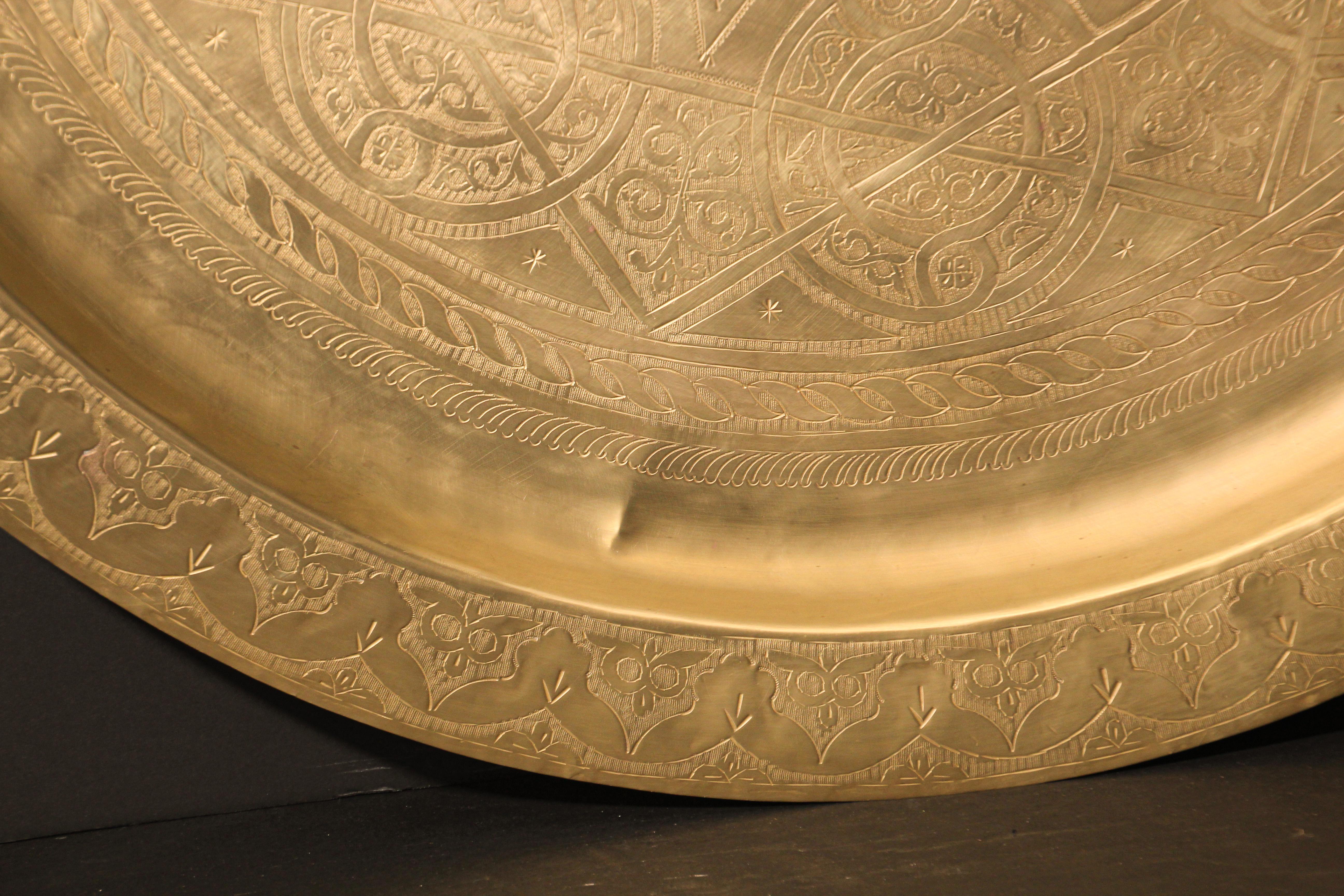 Monumental Moroccan metal polished brass tray platter.
Polished decorative metal brass tray with very fine intricate designs.
Hand-hammered and chiseled in floral Moorish style with a large lotus flower in the middle, pie crust border.
Heavy brass