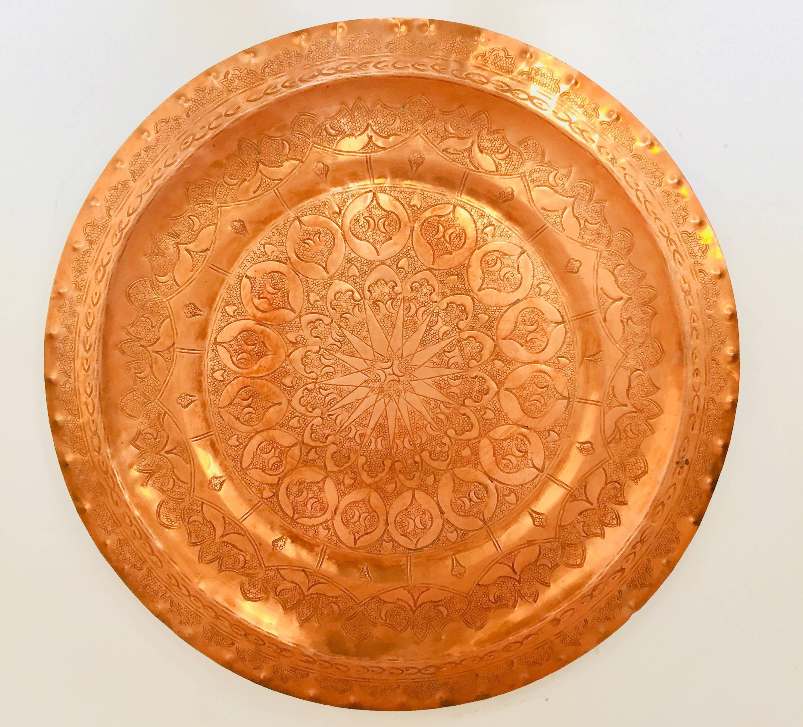 Vintage Moroccan polished round serving metal copper tray platter with traditional geometric Moorish designs.
Handcrafted by Master artisans in Fez, hand-hammered copper using simple tools.
Great brass decorative Islamic Art collector metalwork