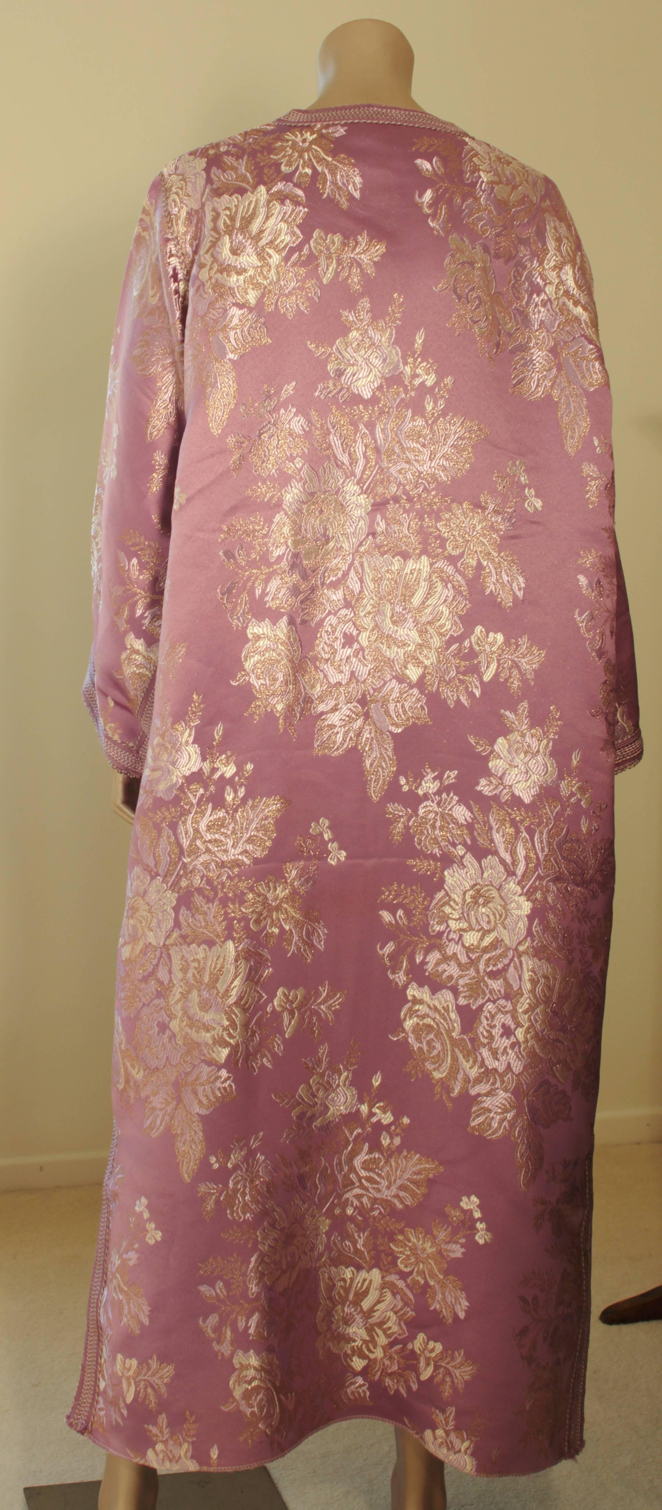 Robe caftan exotique marocaine en brocart métallique, circa 1970.
Ce luxueux caftan est conçu avec un tissu métallique doré brillant.
L'avant de l'élégante robe caftan maxi est agrémenté de boutons dorés tissés et de boucles qui descendent au centre