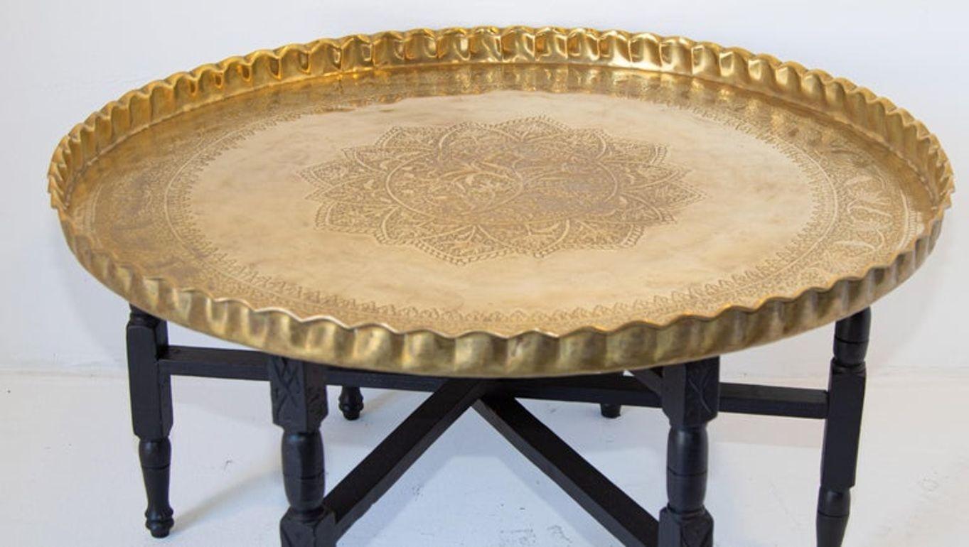 Engraved and embossed large 36 inches round midcentury Moroccan brass tray table.
Polished brass Moroccan tray, very good condition, standing on folding mahogany base with six legs.
Large metal brass polished finely hand-hammered brass tray coffee