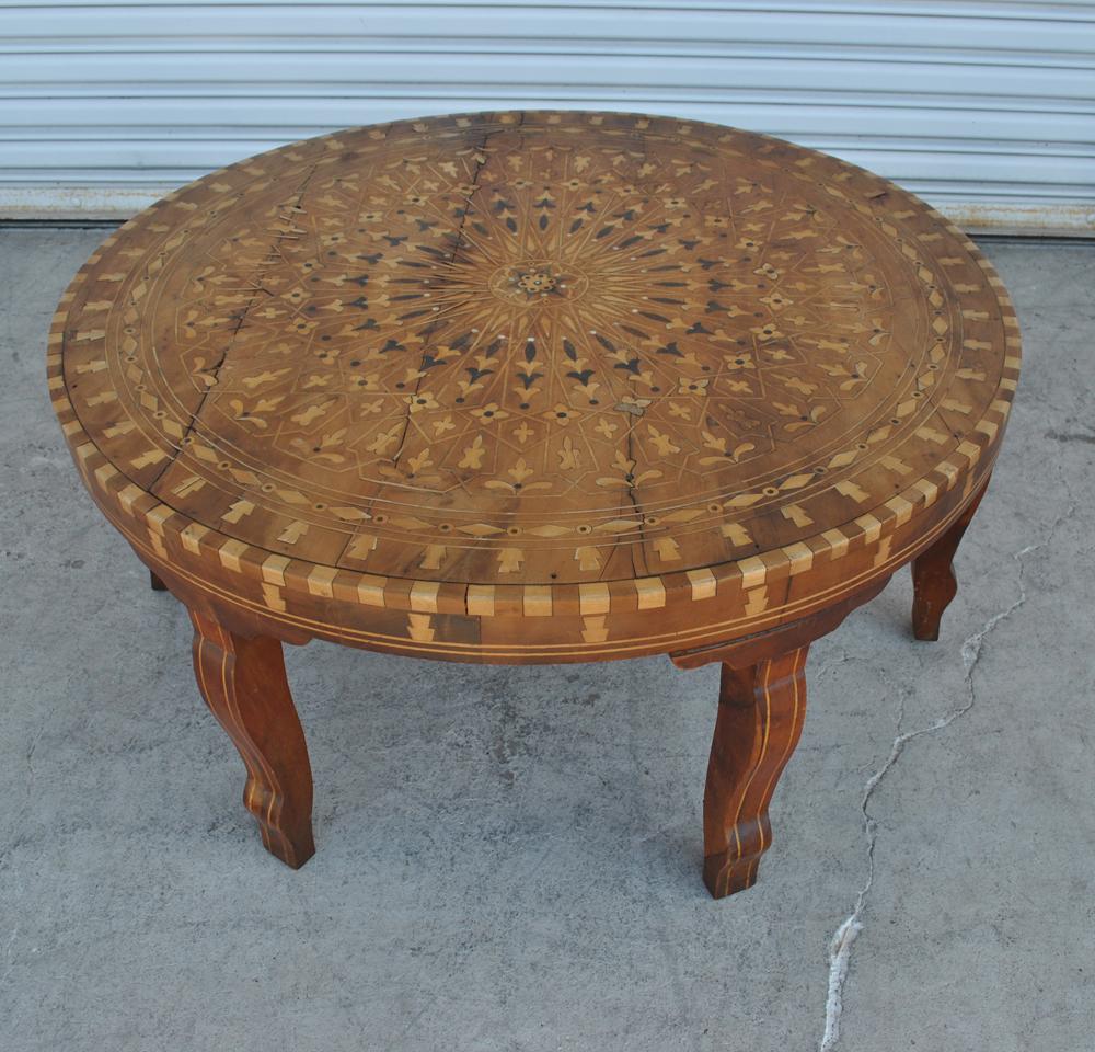 Handcrafted round Moroccan inlaid coffee table, cedar wood inlaid with various fruitwood parquetry and mother of pearl, very nice fine inlaid marquetry work with geometric designs and foliage. Coffee table from Essaouira, Morocco. The specialty of