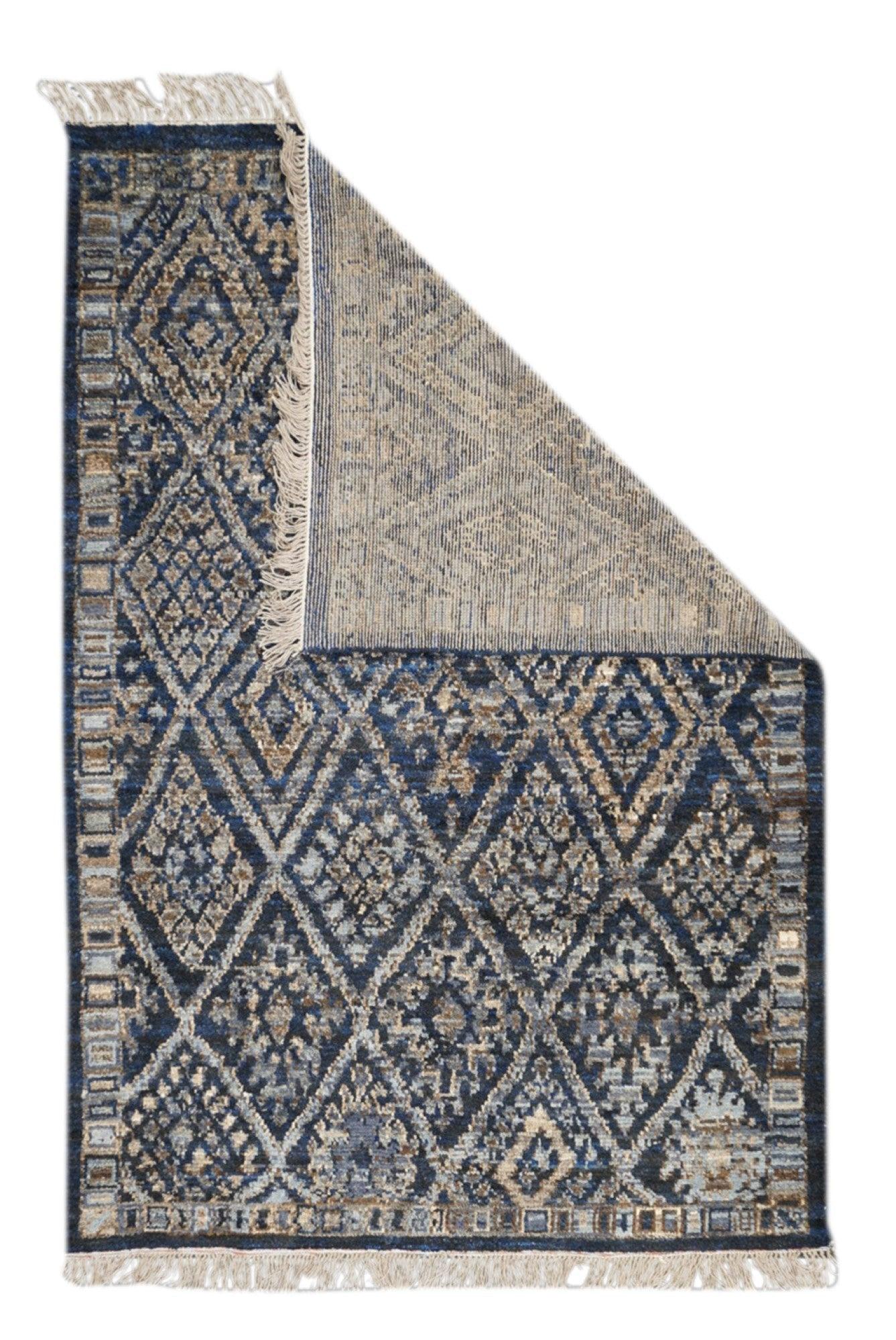 Tappeto marocchino 5'9'' x 8'4''. Il campo blu scuro abraso mostra un grande reticolo a losanghe che racchiude varie composizioni floreali semi-geometriche conformi alla riserva, all'interno di uno stretto bordo di quadrati e rettangoli. Bordo
