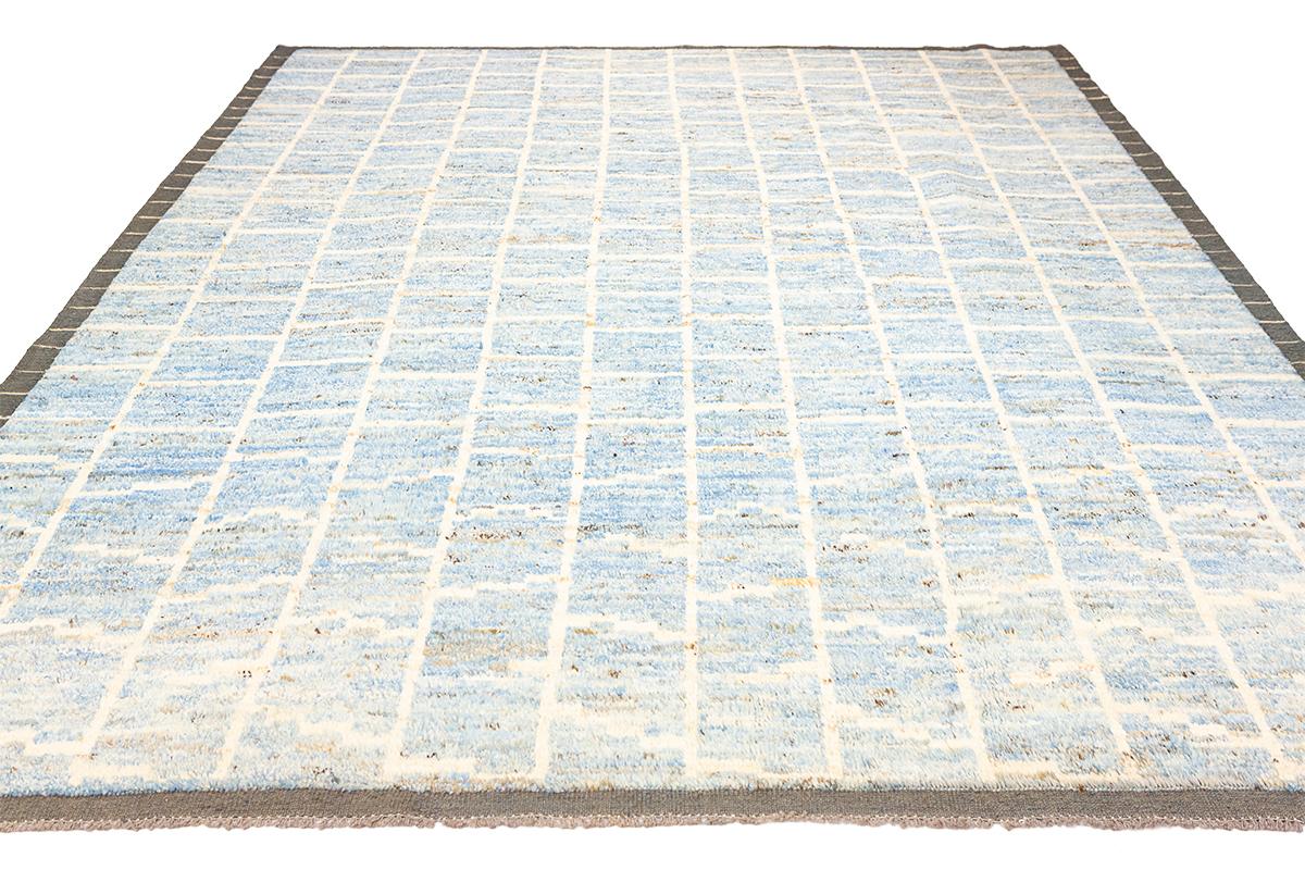 This is an exquisite Moroccan Rug, a handmade masterpiece crafted from genuine sheep wool. This rug stands out with its soft blue and off-white colors and minimalist design, offering a unique blend of simplicity, elegance, and comfort. What makes