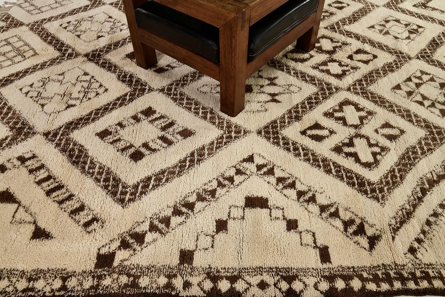 A stunning Moroccan Middle Atlas Tribe rug that features earthy tones of brown and beige. Embodying these gorgeous variegated symbolic lozenge panels, this wondrous rug is enclosed with a series of diamond borders. A revitalizing piece that will add