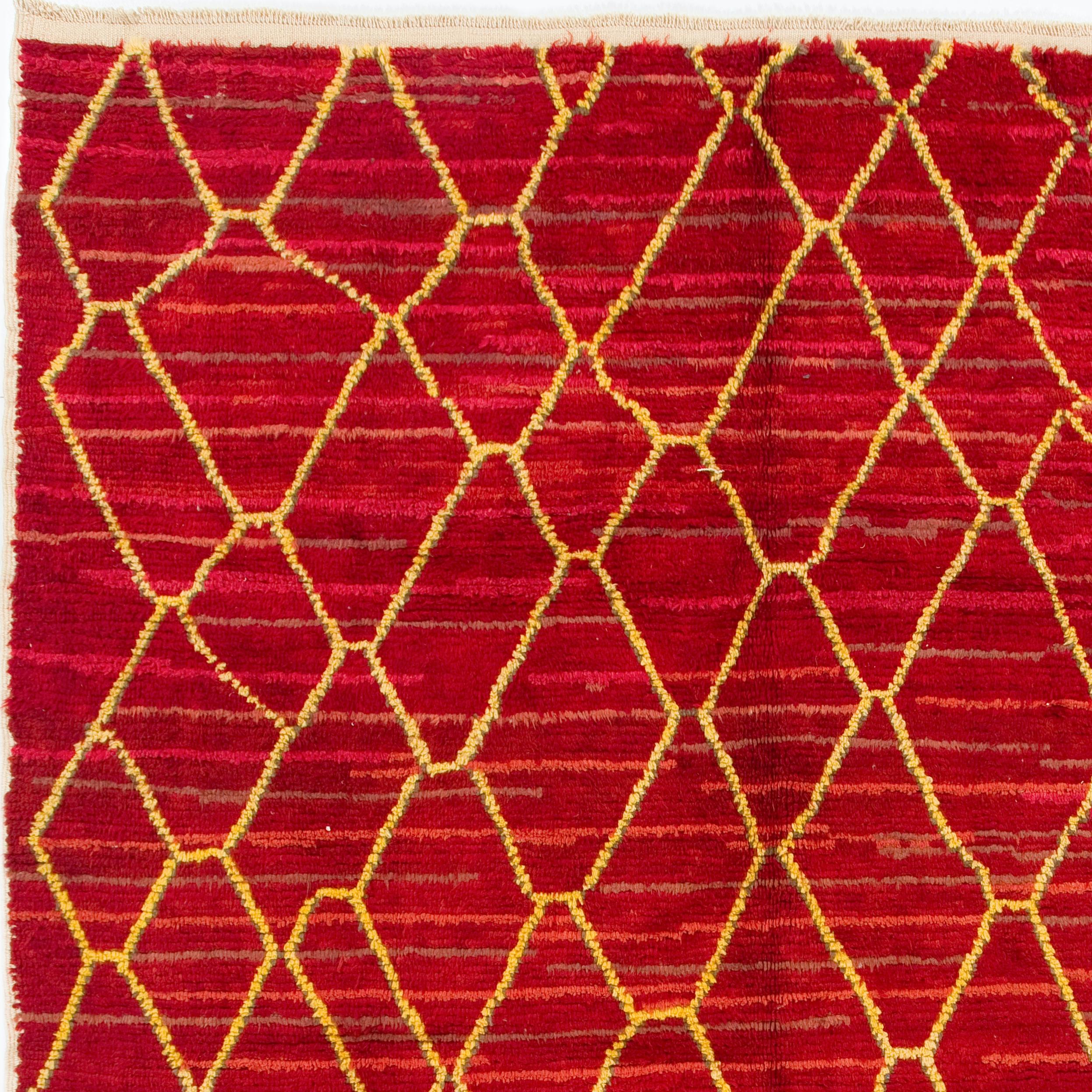 A contemporary hand knotted Moroccan rug inspired by the Berber culture in the Atlas Mountains, with soft velvety pile, made of hand-spun natural lambs-wool. It has an overall loose lattice design in yellow against a richly colored field in tomato