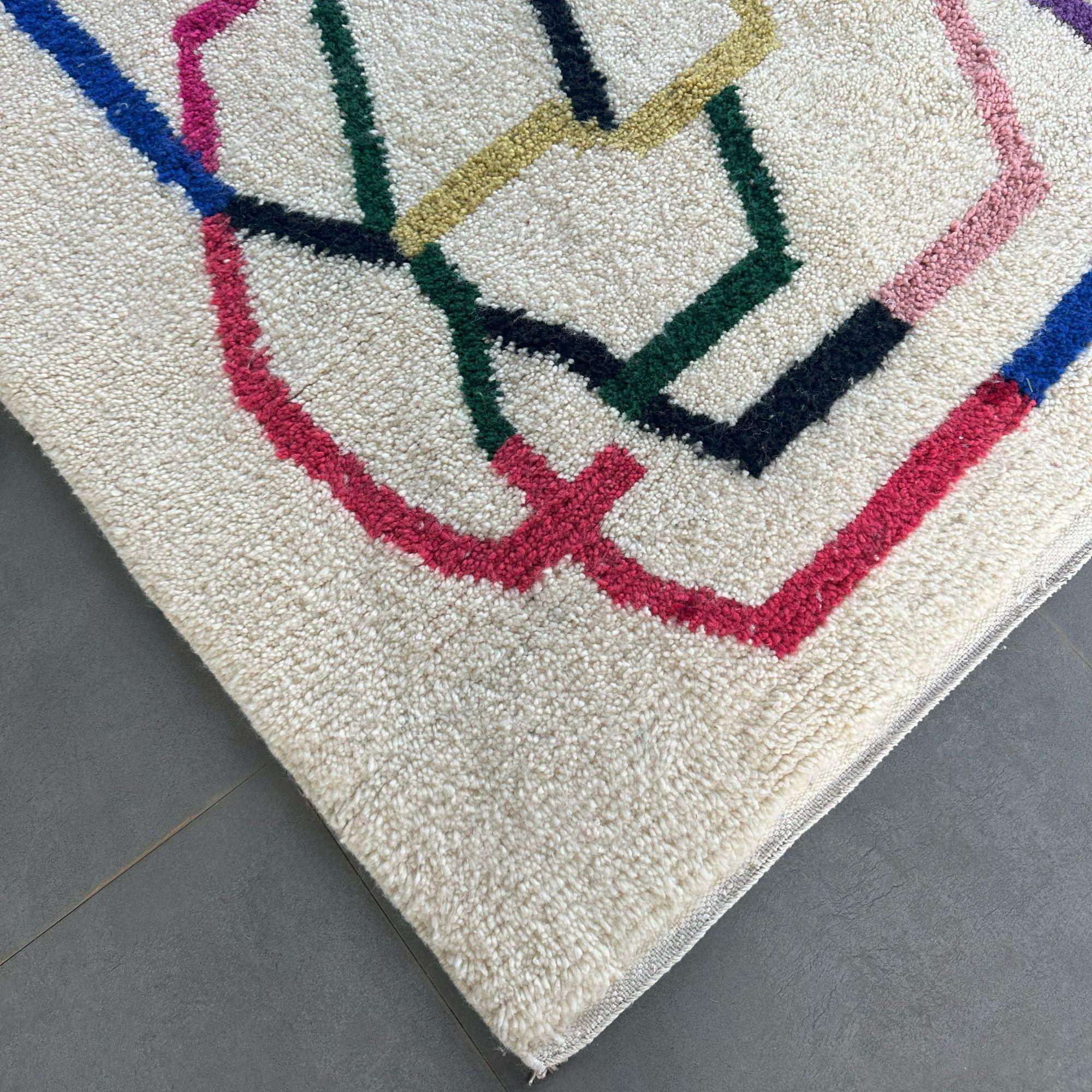 Découvrez l'élégance du tapis marocain blanc Tranquil Trails, doté d'une touche de couleur contemporaine qui ajoute une touche de modernité à tout espace. Tissé à la main par des artisans berbères, ce tapis est fabriqué à partir de laine naturelle