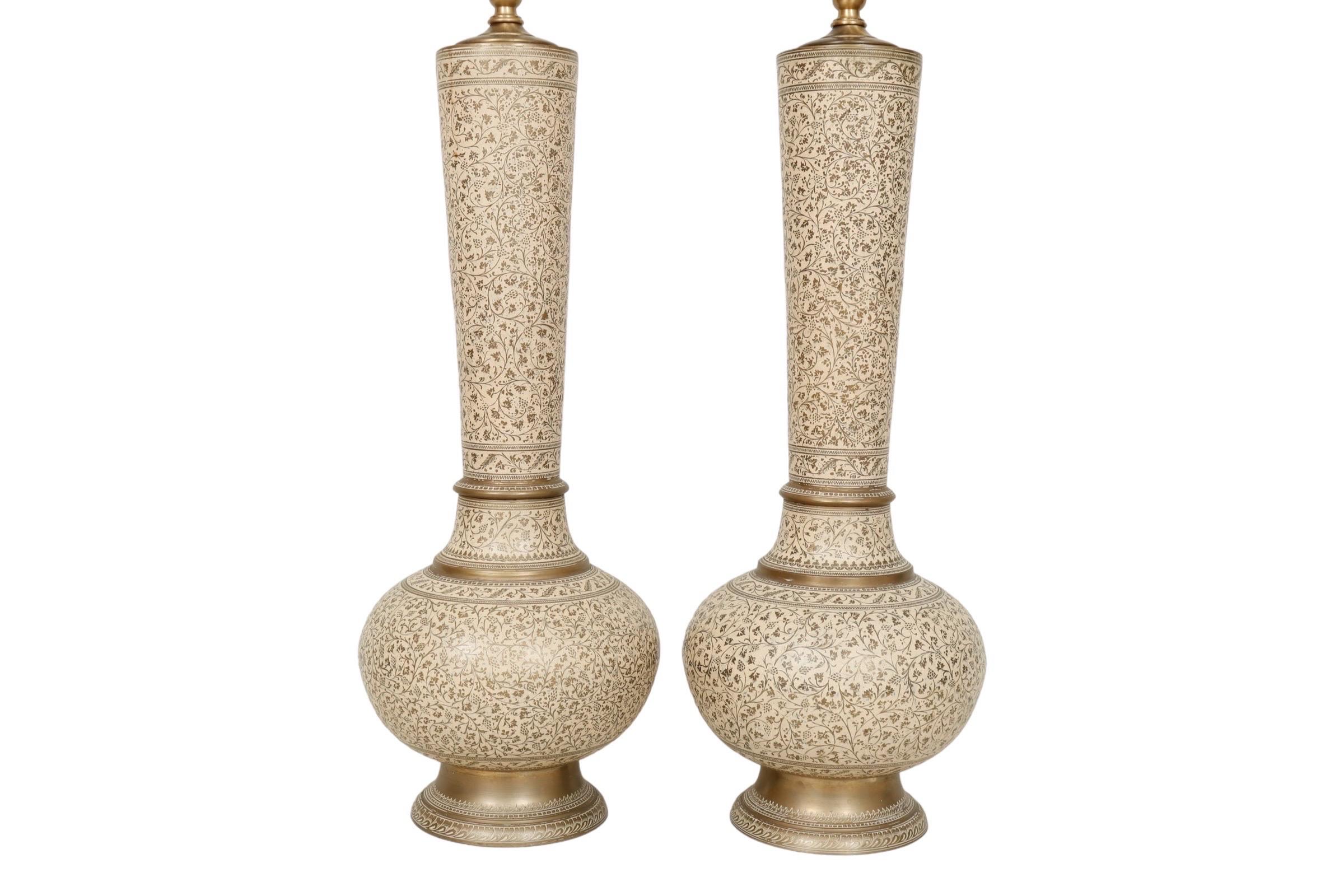 Coppia di lampade da tavolo marocchine in ottone. I vasi alti in ottone smaltato sono decorati con graffiti a forma di uva e vite. Le basi rotonde a gradini sono incise. Ogni lampada misura 25