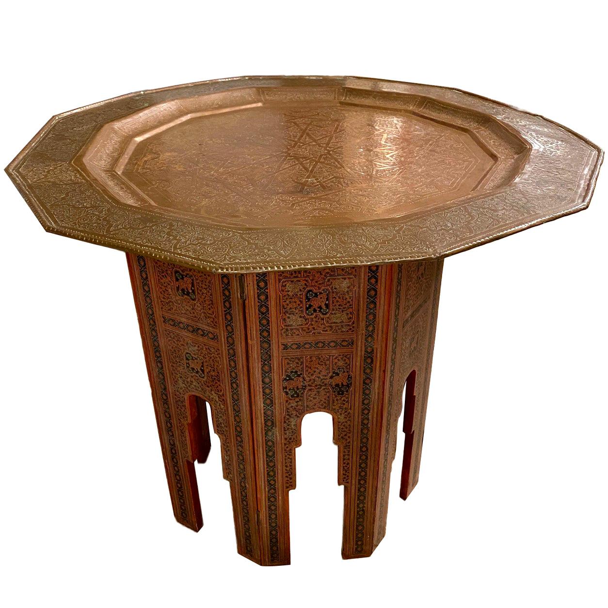 Ein marokkanischer Tisch mit bemaltem Holzsockel und arabeskengeätztem Metalltablett aus den 1940er Jahren.

Abmessungen:
Höhe: 28