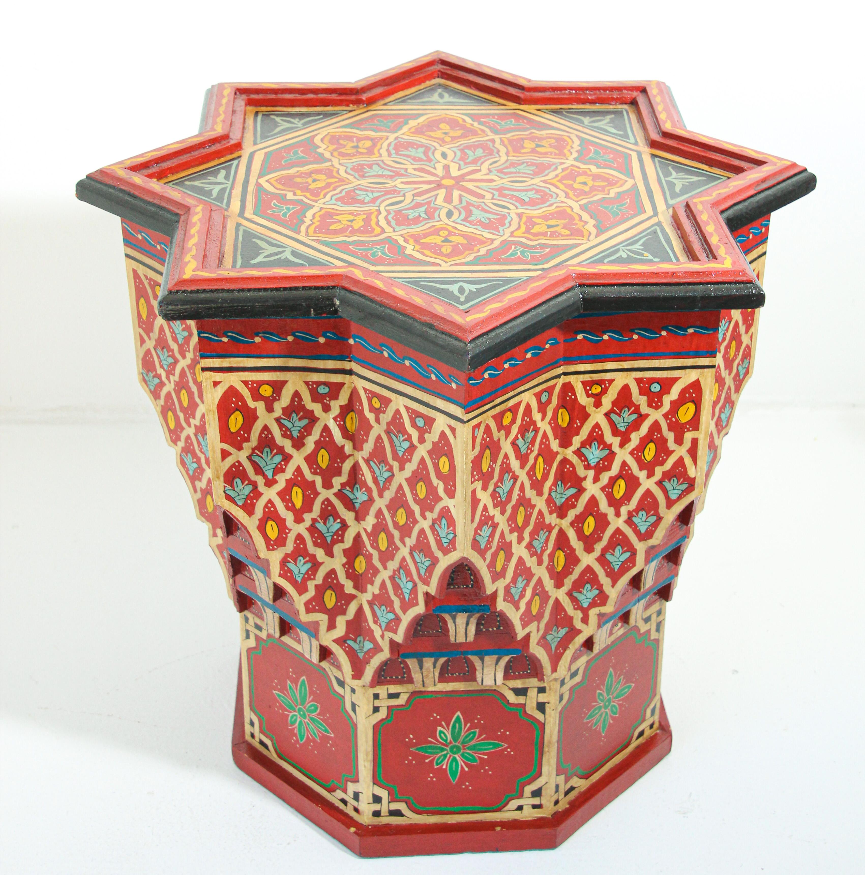 Moroccan colorful red hand painted and carved side occasional table with Moorish designs.
Pedestal table in red background with multicolored floral and geometric designs.
Very decorative fine artwork on a star shape top design.
Hand painted in