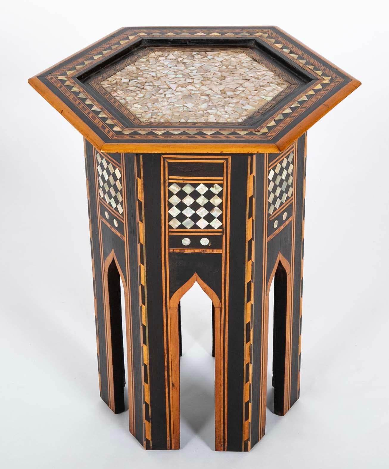 Moroccan hexagonal side table with mother of pearl, ebony and fruit wood inlay. The top and sides inlaid with geometric, triangular, diamond and circular patterns to create a harmonious whole. The ebony offset and highlighted by the fruit wood to