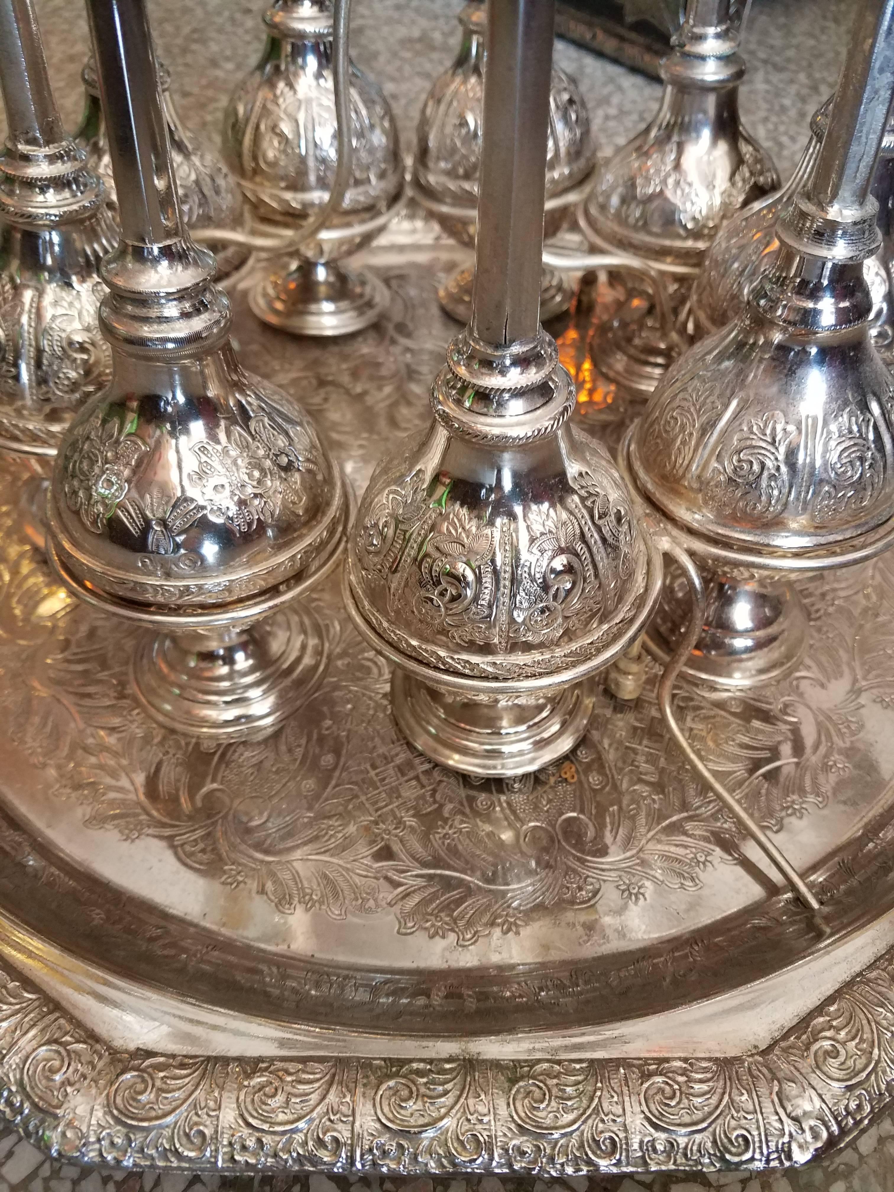 Vintage/authentic Moroccan set of silver rosewater bottles, total of nine, a silver handle and a silver tray. Each dispenser can be filled with rosewater or orange blossom water and each nozzle has piercings from which rosewater can be sprinkled.